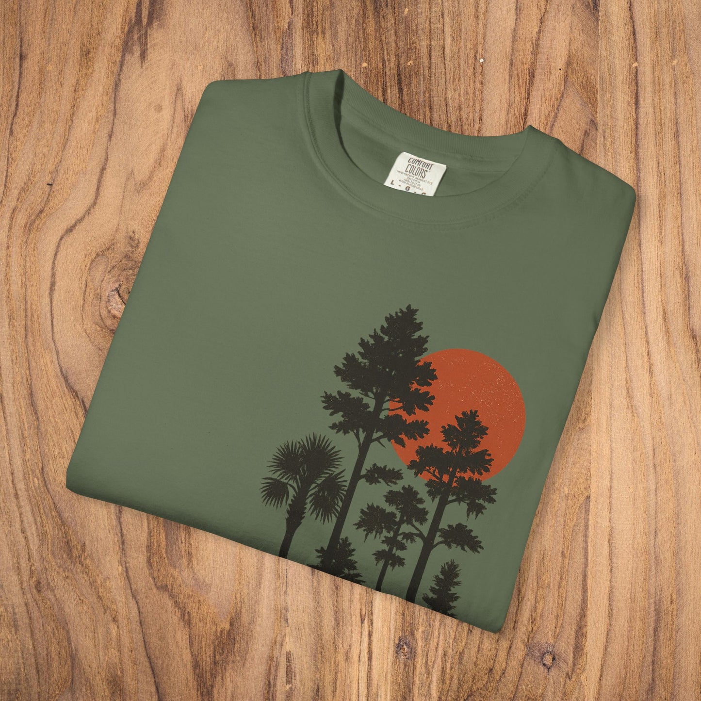 Folded Sunset Trees Unisex T-Shirt in olive green highlighting the soft fabric and artistic design, ideal for nature lovers.