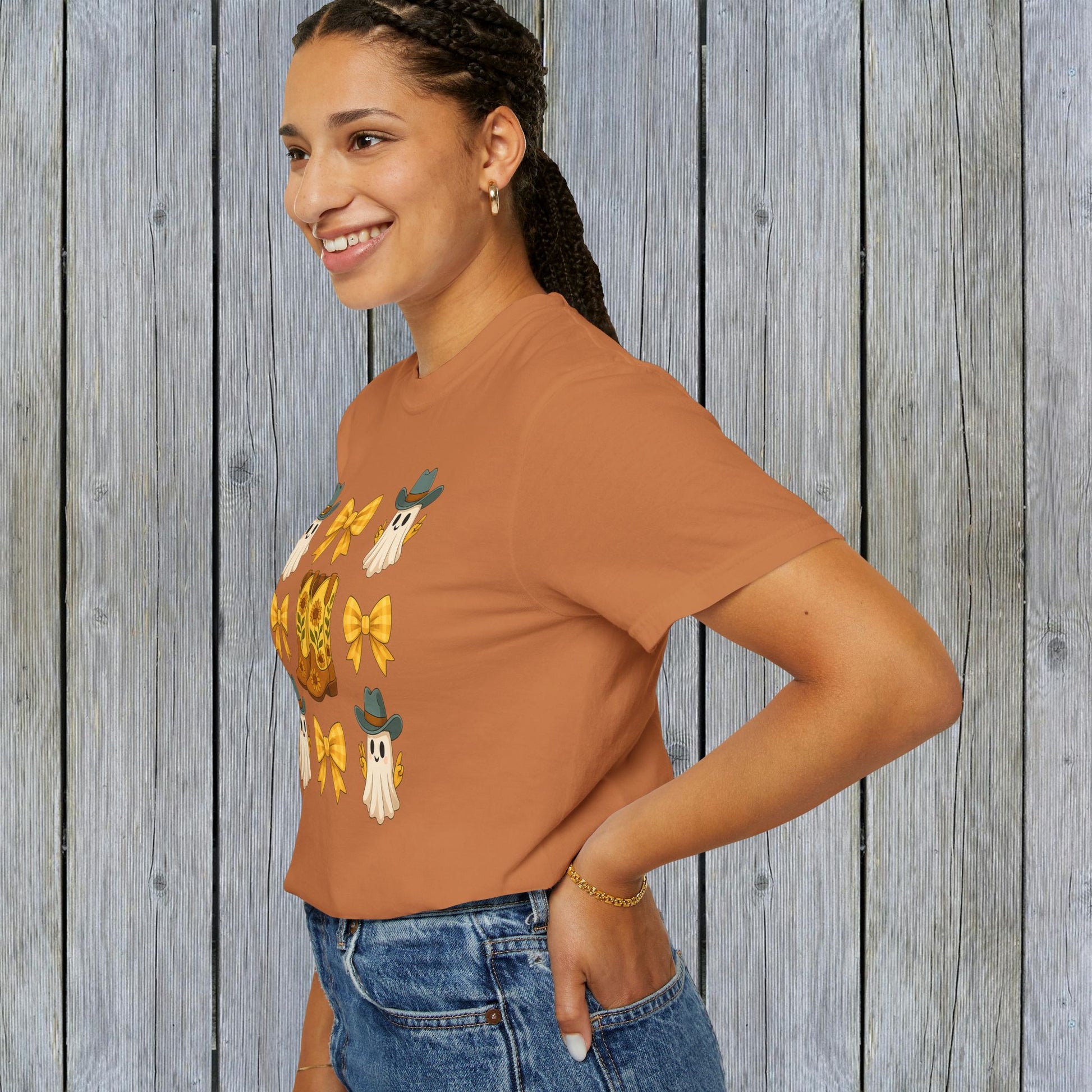Smiling model in a Cute Halloween T-Shirt with a vibrant design of ghosts and cowboy boots, highlighting eco-friendly fashion for the fall.