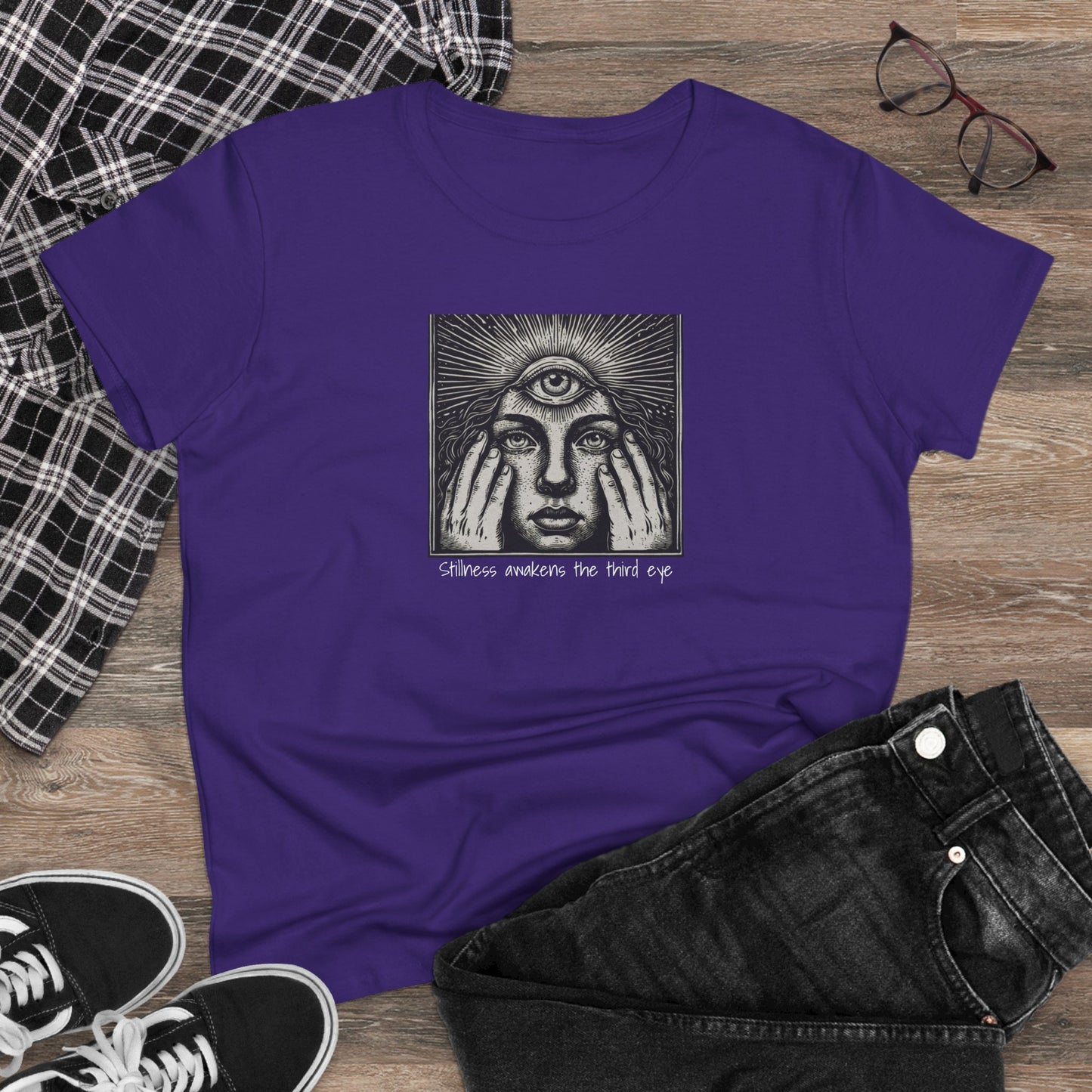 Stylish Third Eye Graphic Tee casually styled on a wooden surface next to plaid fabric and sneakers, showcasing its trendy cropped fit and distinctive third eye design.