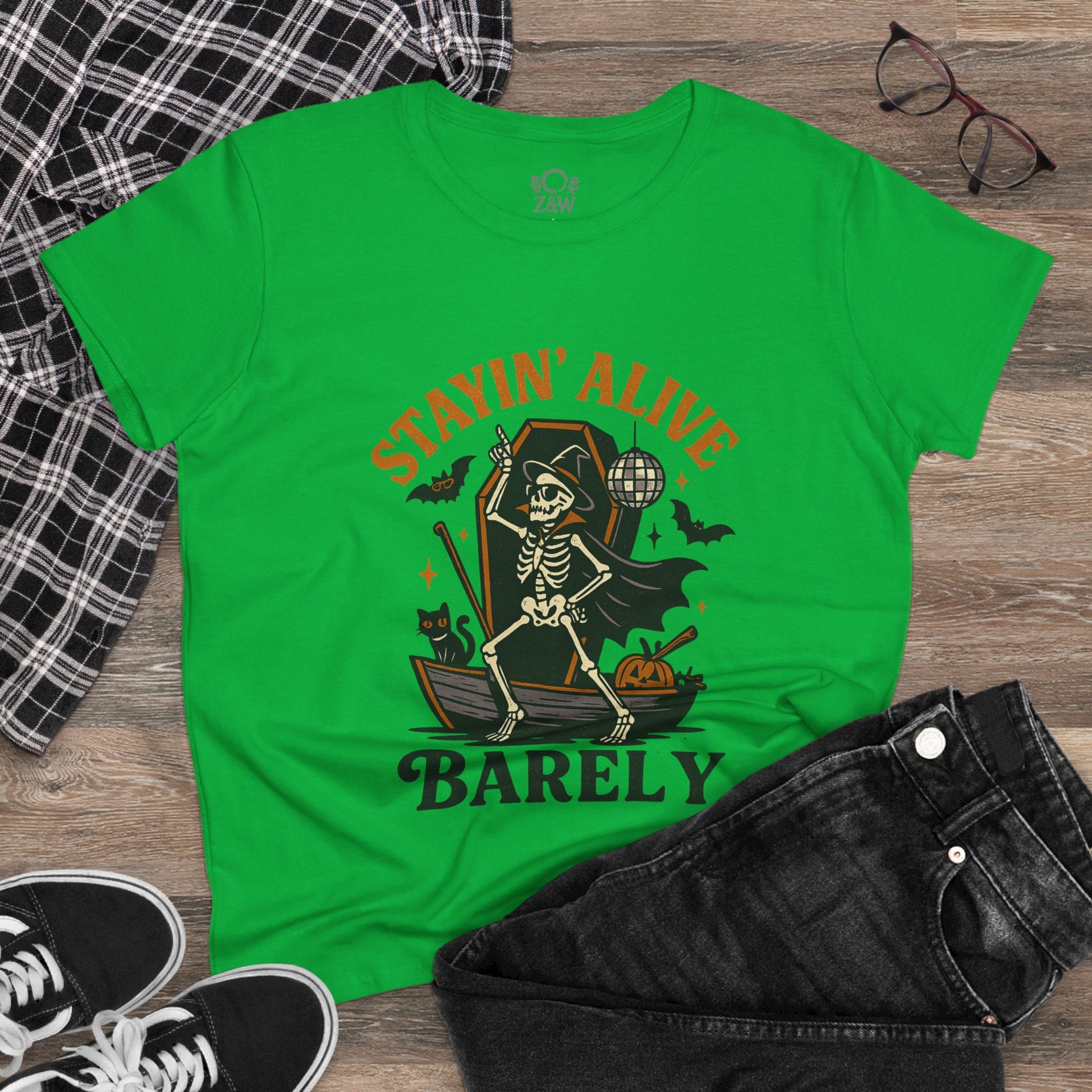 Stayin’ Alive T-Shirt in a vibrant green, showcasing a whimsical skeleton with accessories. Ideal for Halloween parties or casual outings.