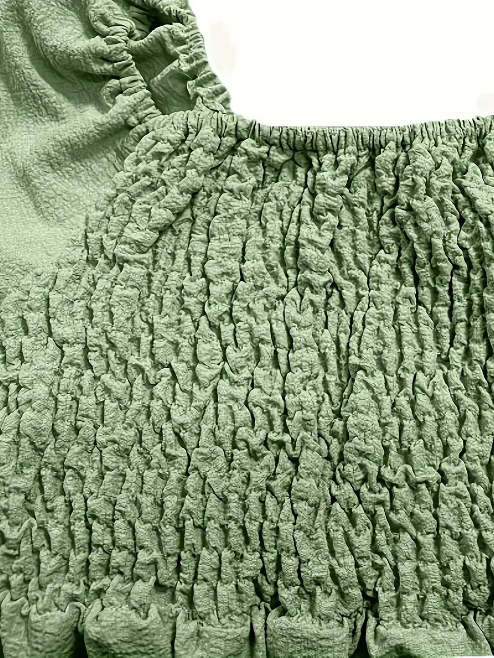 Close-up of the ruched fabric of a full size ruffled off-shoulder dress in green, showcasing its stretchy and chic design.