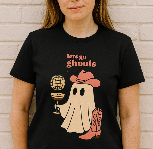 Let's Go Ghouls Tee featuring a playful ghost in a cowboy hat holding a cocktail, perfect for Halloween and festive occasions. Made of 100% cotton for a soft fit and available in sizes S-3XL.