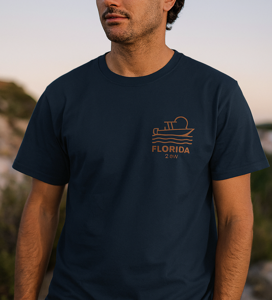 Unisex Florida Graphic Tee featuring a boat design, showcased on a model against a scenic backdrop, made from soft garment-dyed US cotton, available in sizes S-4XL, ideal for casual wear.
