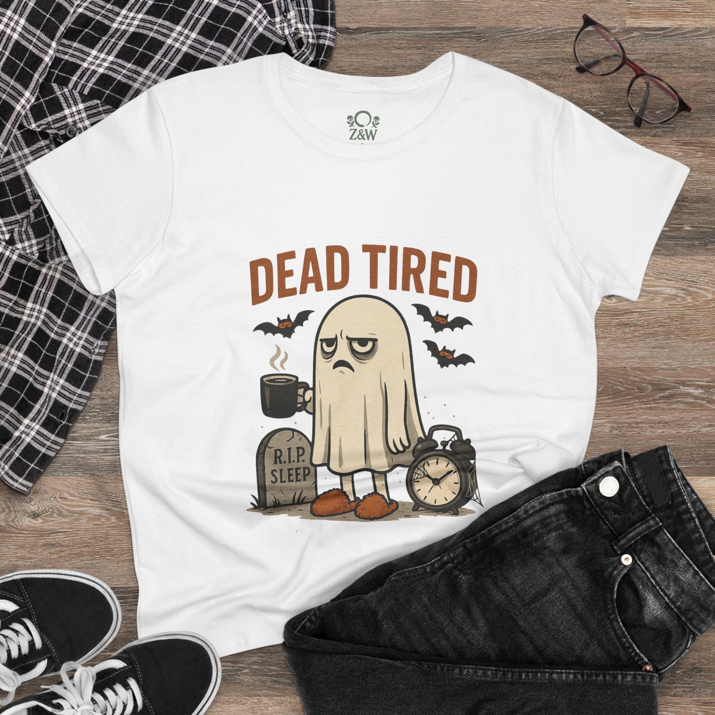 Model wearing a Cute Whimsical Ghost T-Shirt for Halloween with a cartoon ghost and 'DEAD TIRED' text, styled with black jeans and sneakers, ideal for spooky season.