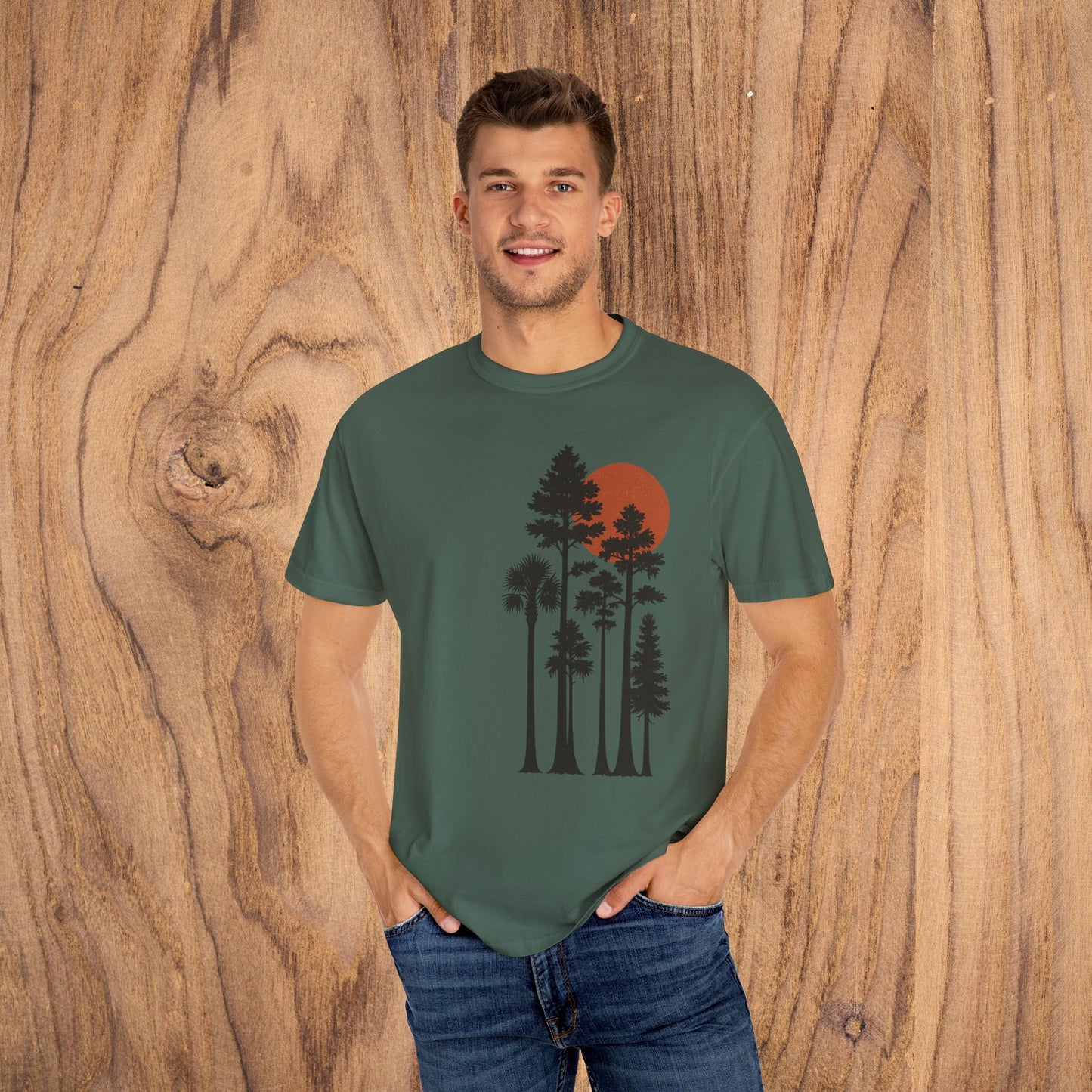 Model wearing Sunset Trees Unisex T-Shirt in forest green, featuring a striking sunset design and perfect for casual outings.