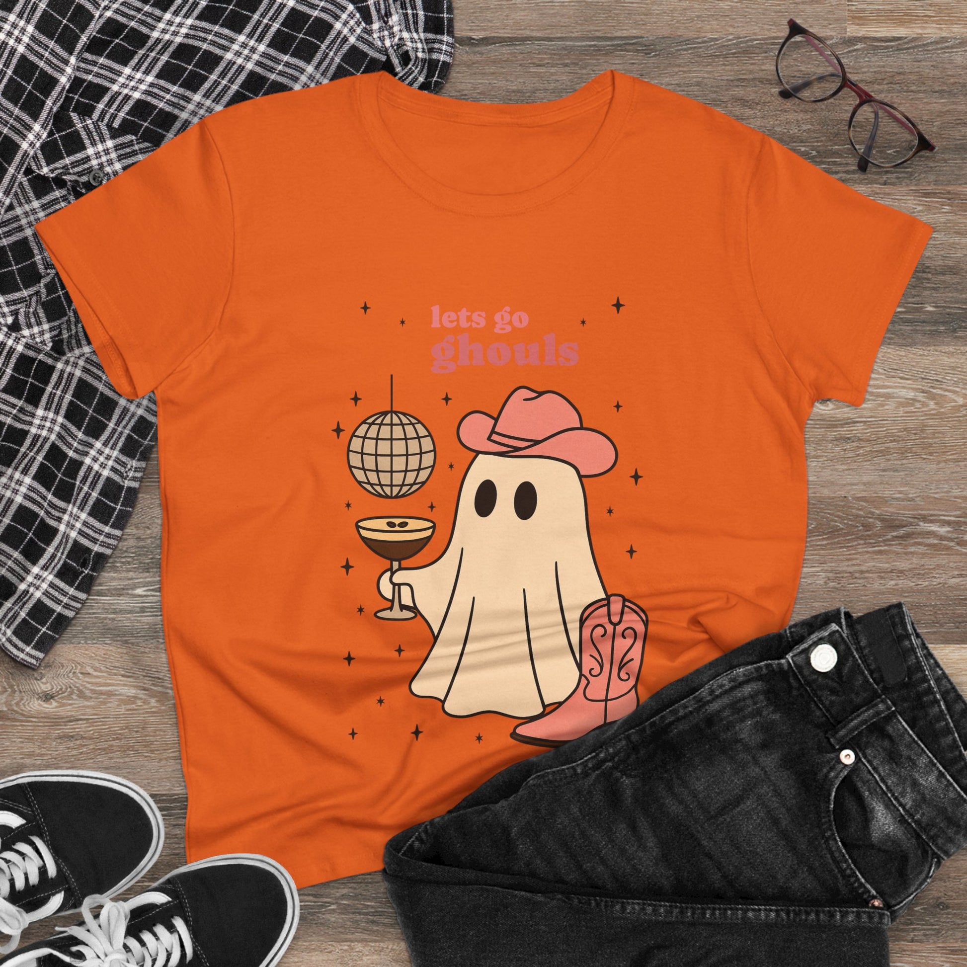 Let's Go Ghouls Tee in orange showcasing a whimsical ghost character with a drink, an excellent choice for Halloween festivities.