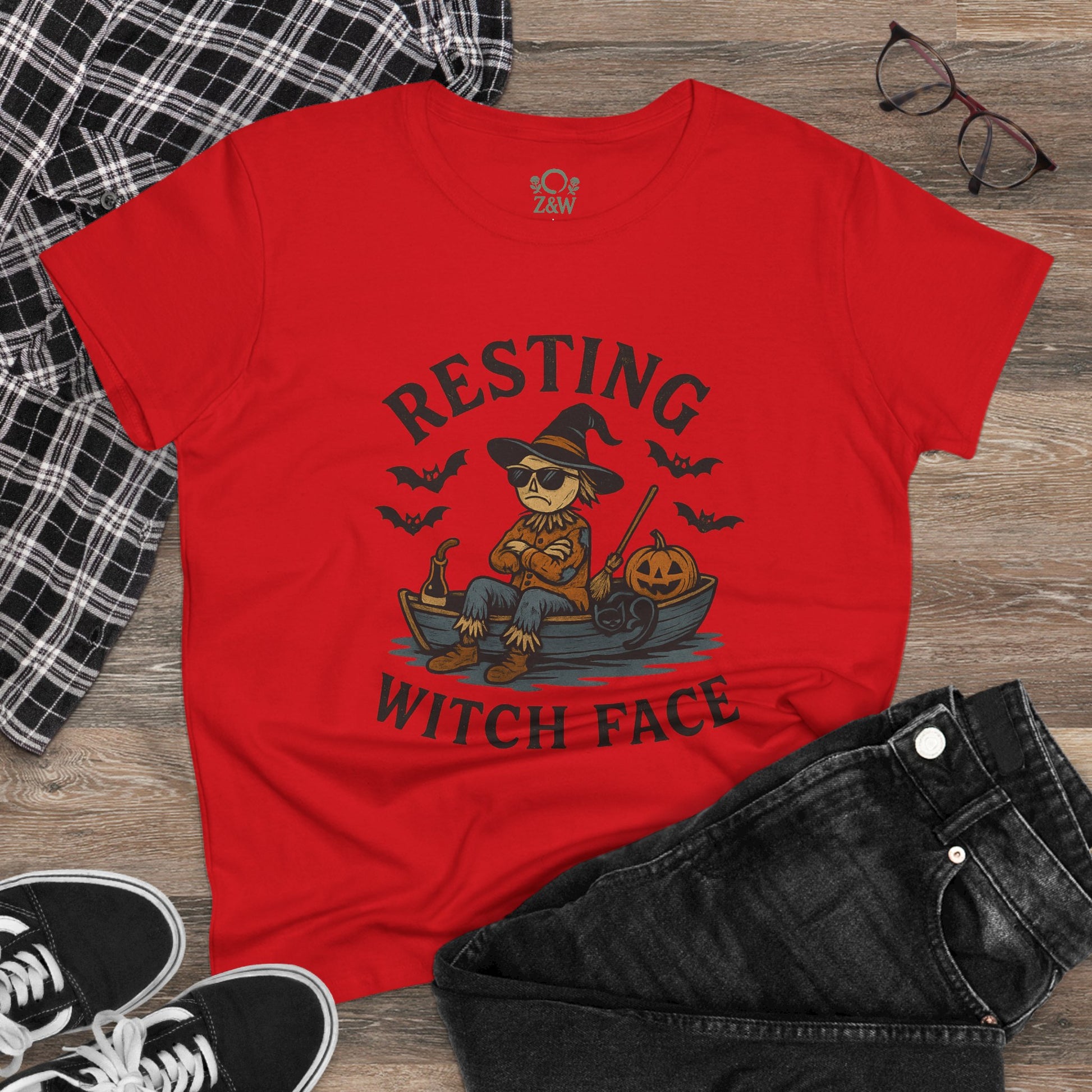 Resting Witch Face Halloween T-Shirt for Women in lively red, styled with denim and sneakers on a wooden surface, perfect for a trendy Halloween outfit.