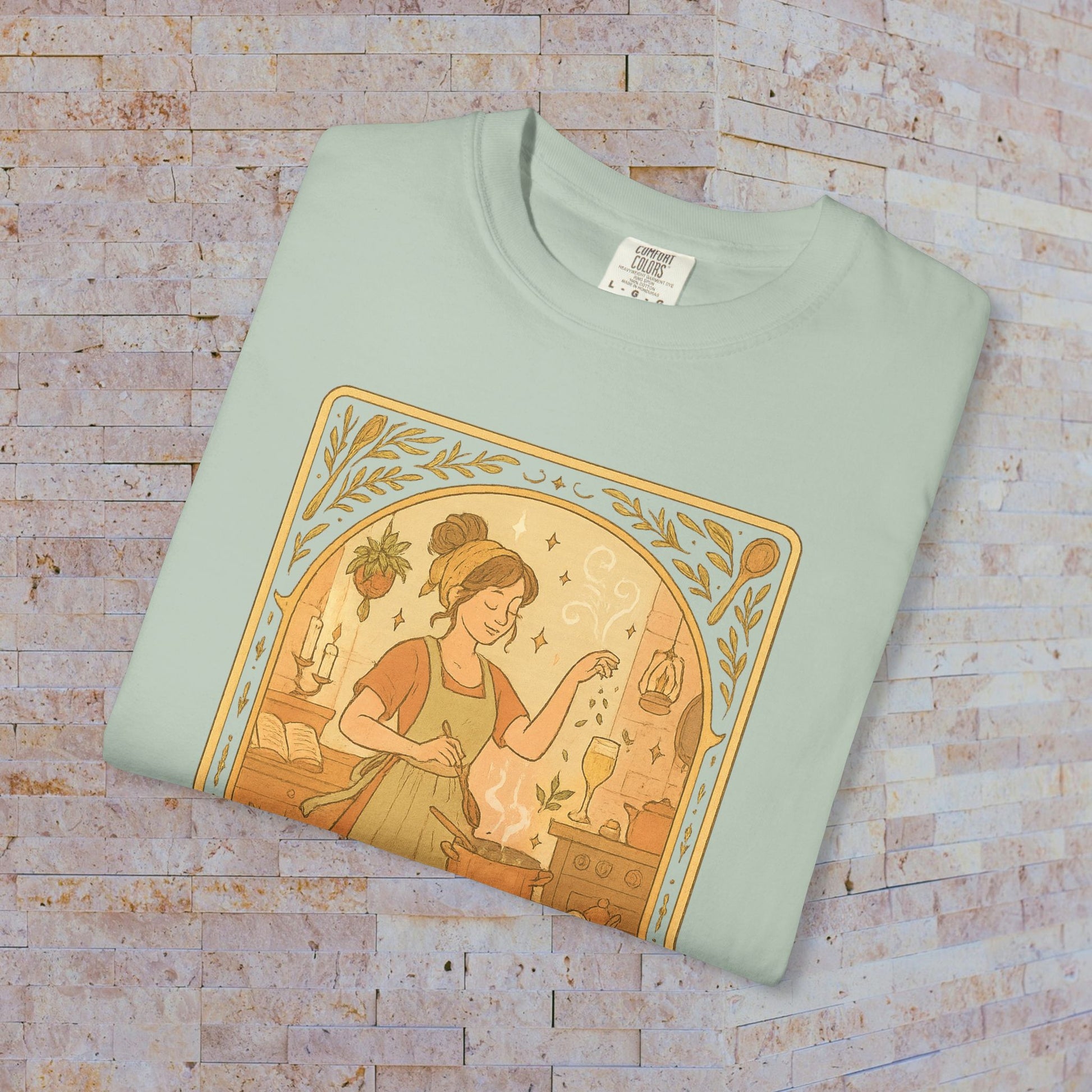 Culinary Queen Tarot Tee in pastel green, featuring a delightful design of a woman preparing food, available in sizes S to 4XL, crafted from soft cotton material.