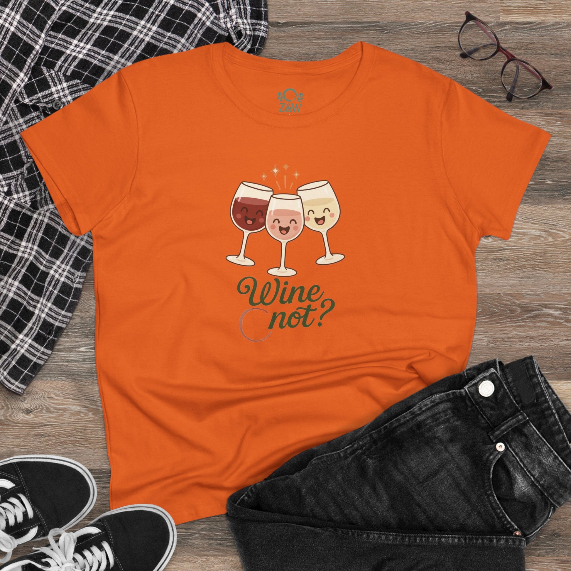 Wine Not Tee featuring three cartoon wine glasses and the phrase 'Wine not?' on an orange background, made from 100% ring-spun cotton.