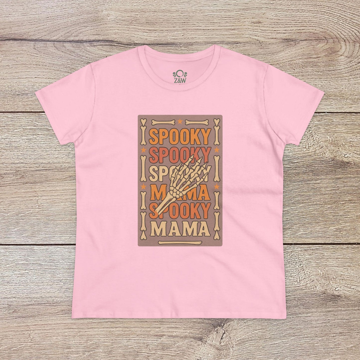 Spooky Mama Tee in pastel pink displaying a fun Halloween graphic with a skeleton hand, made with ethically sourced soft cotton for comfort.