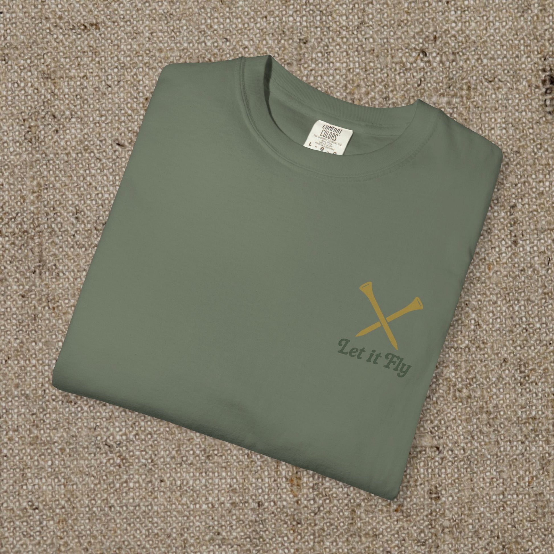 Folded Tee It High Let It Fly Graphic Tee in olive green featuring a sophisticated design with crossed golf clubs on the front, perfect for golf lovers.