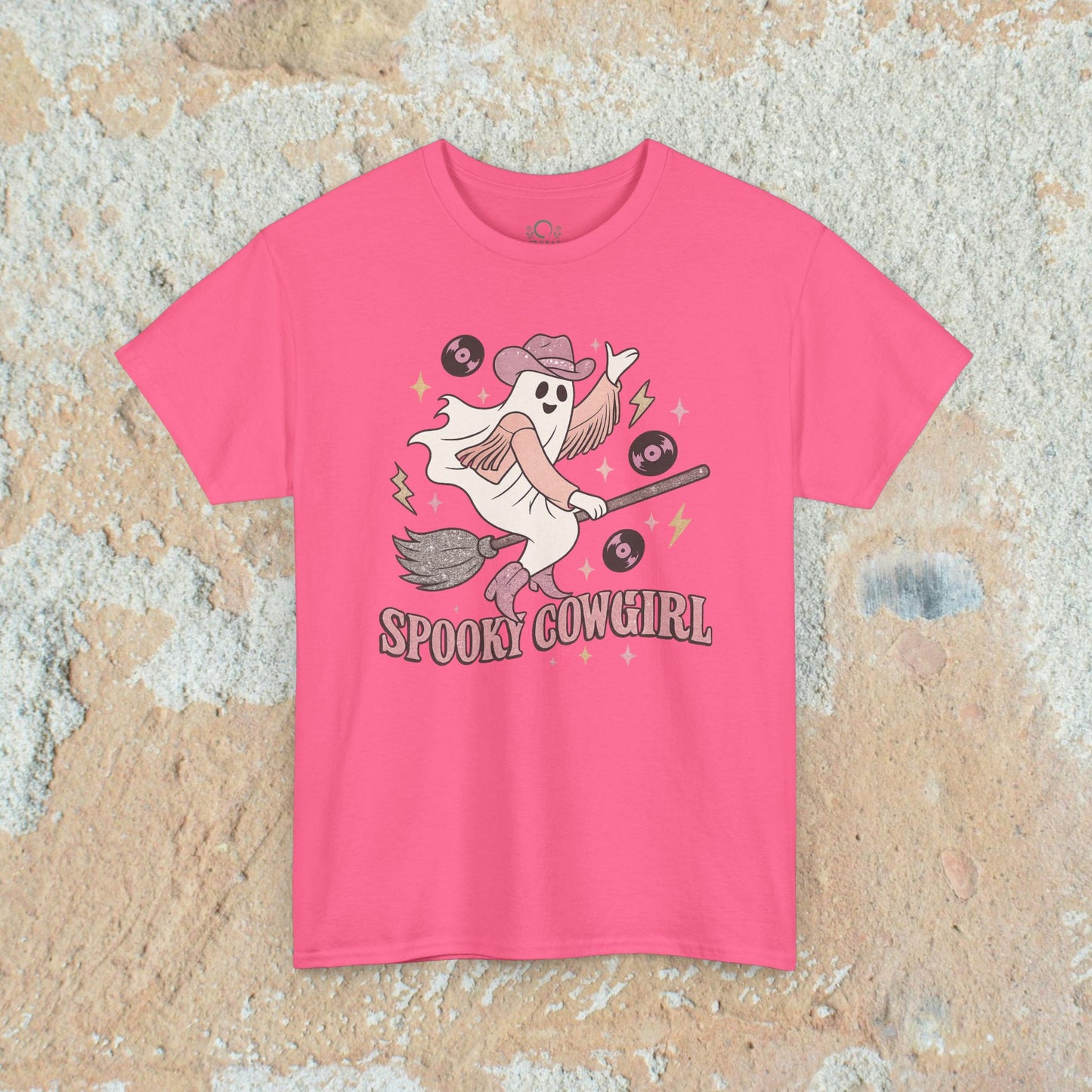 Stylish pink Spooky Cowgirl graphic tee design that captures a cheerful ghost with a broomstick and vinyl records, a must-have for Halloween lovers. Offered in sizes S to 5XL.