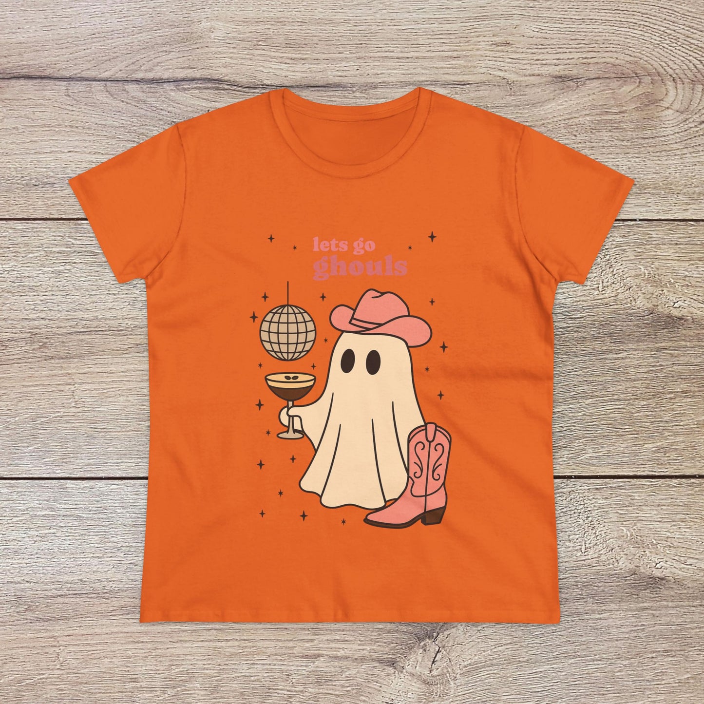 Let's Go Ghouls Tee in vibrant orange depicting an adorable ghost with boots and a drink, perfect for Halloween festivities and fun casual outfits.