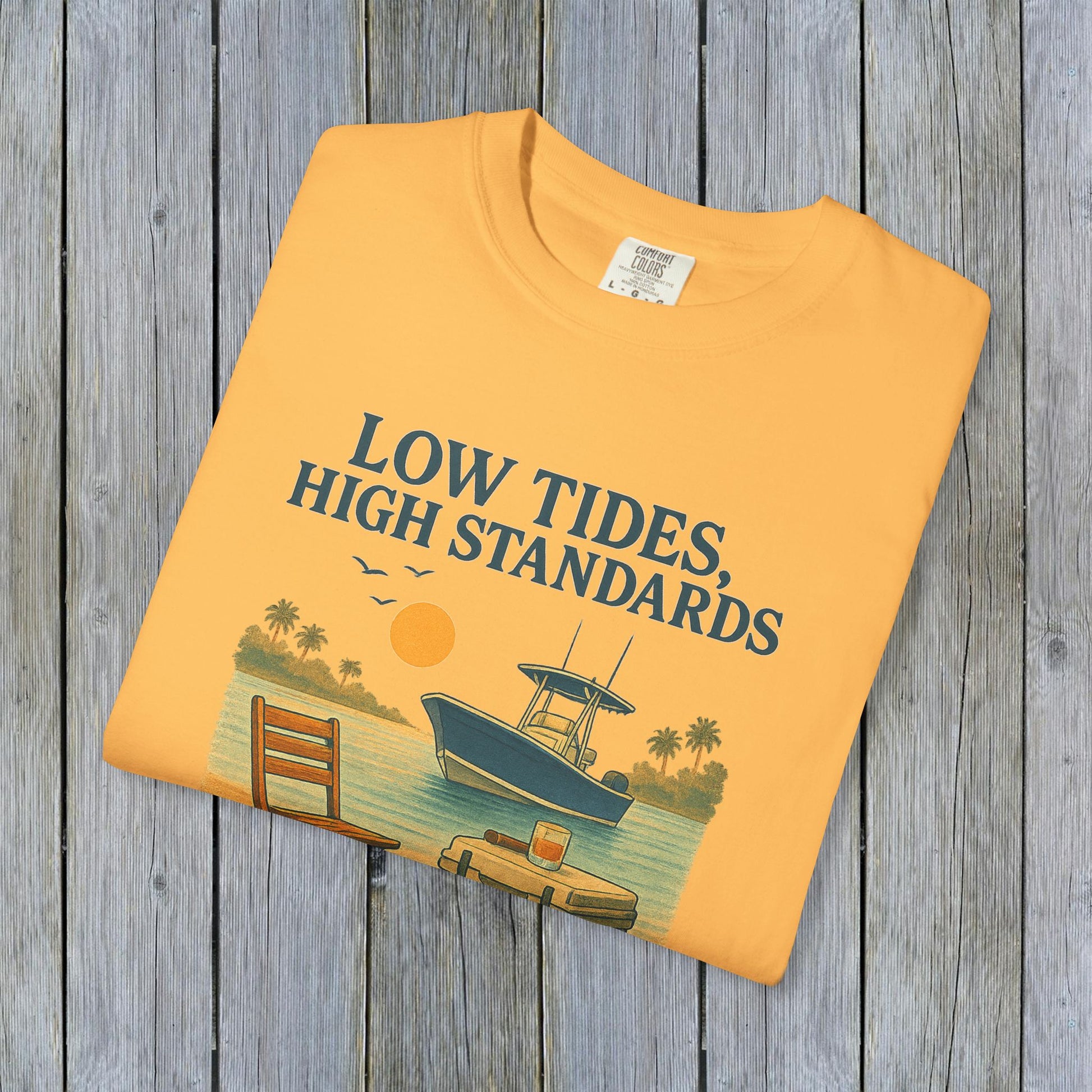 Folded garment-dyed Low Tides High Standards T-Shirt in bright orange, showcasing a beach scene print, ideal for casual outings.