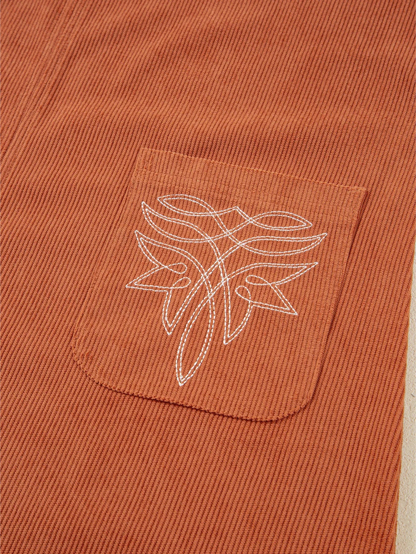 Close-up of the embroidered patch pocket on the Corduroy Western Mini Dress With Embroidered Patch Pocket, highlighting the intricate design and perfect blend of fashion and function.