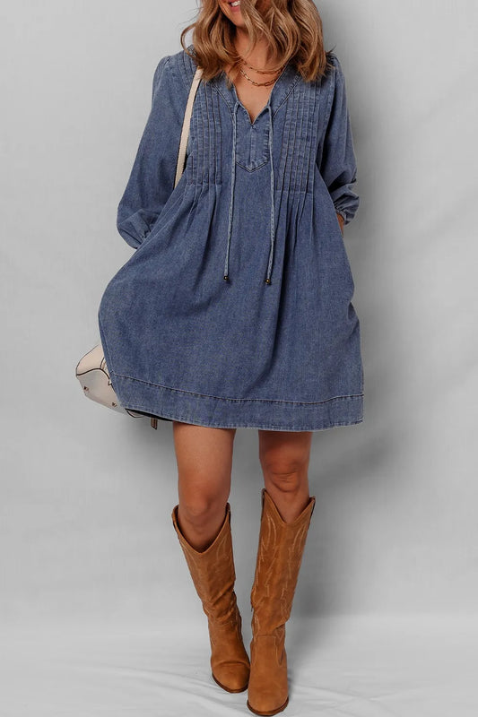 Close-up of a model wearing a Tie Neck Long Sleeve Mini Denim Dress, highlighting the unique pleated design and chic footwear.