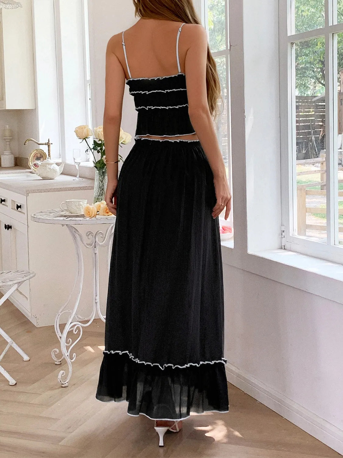 Back view of a model in the black Two-Piece Frill Square Neck Cami and Ruched Skirt Set in Stretchy Lyocell Blend, emphasizing the chic frill details and graceful skirt.