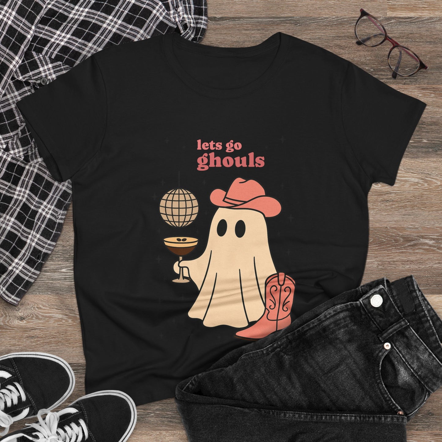 Let's Go Ghouls Tee in black featuring a playful ghost design holding a drink and wearing a hat, perfect for fun Halloween outfits.