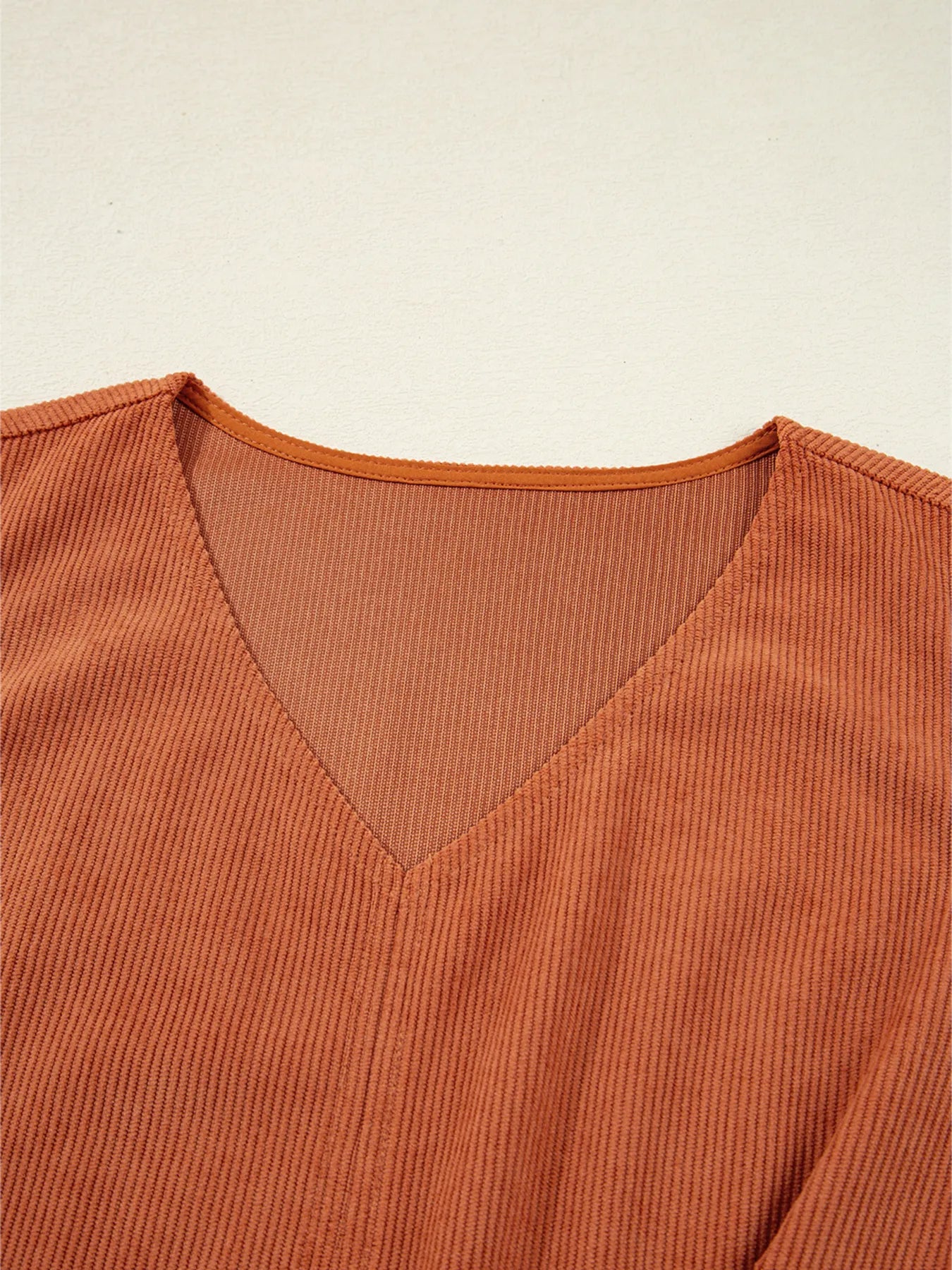 Close-up of the neckline of the Corduroy Western Mini Dress With Embroidered Patch Pocket, showcasing its ribbed texture and stylish cut.
