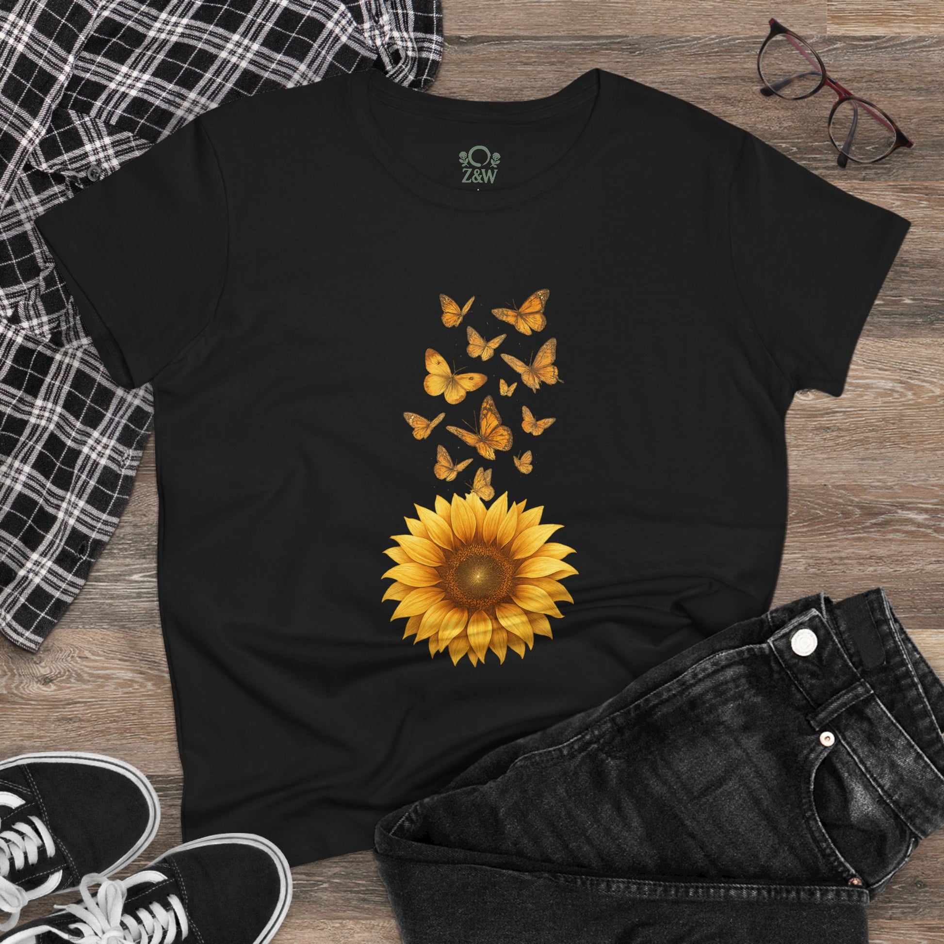 Sunflower & Butterflies Cotton Tee for Women on a wooden surface, with a detailed sunflower and butterfly print, demonstrating its breathable and durable 100% cotton construction.