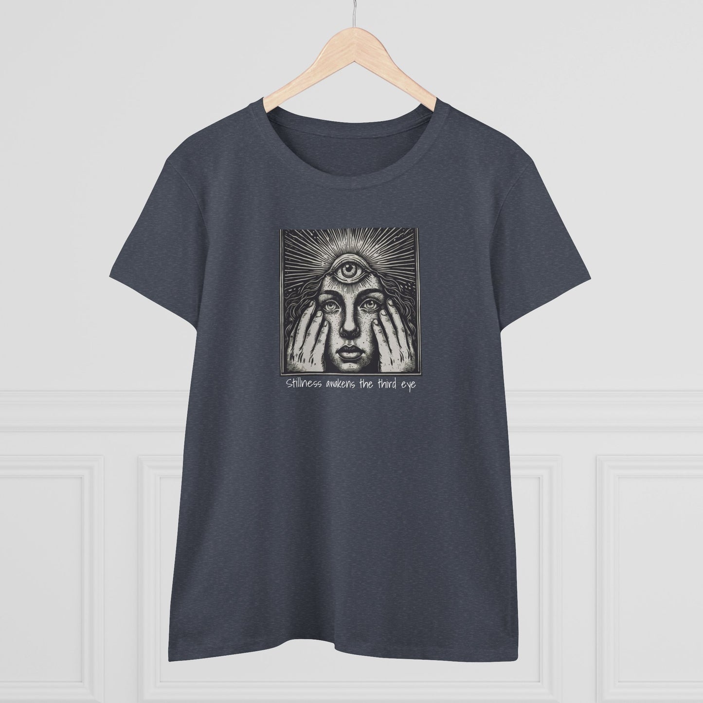 Stylish Third Eye Graphic Tee displayed on a wooden hanger, featuring a unique design with a third eye and text, symbolizing awareness and intuition. Made from 100% cotton for a comfortable fit.
