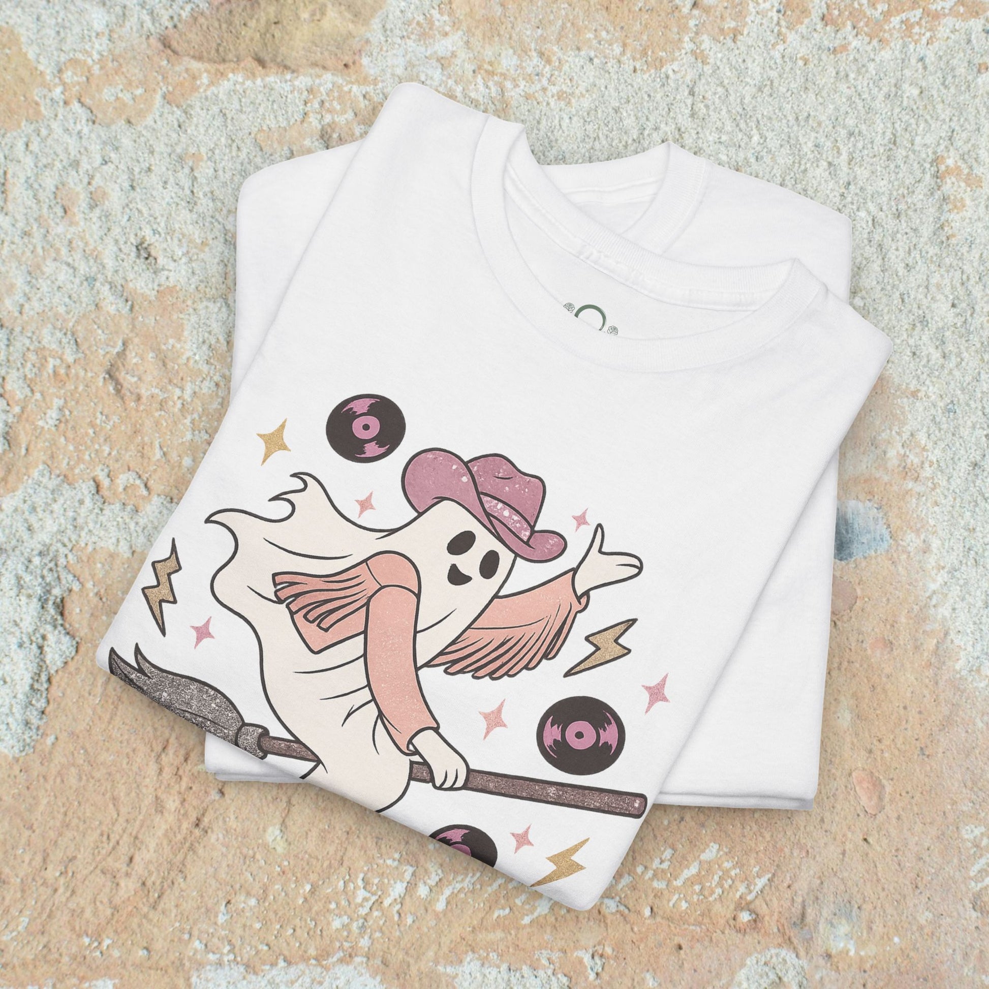 Spooky Cowgirl Graphic Tee showcasing a cute ghost in a cowboy hat on a broomstick, ideal for layering, designed for a fun Halloween look.