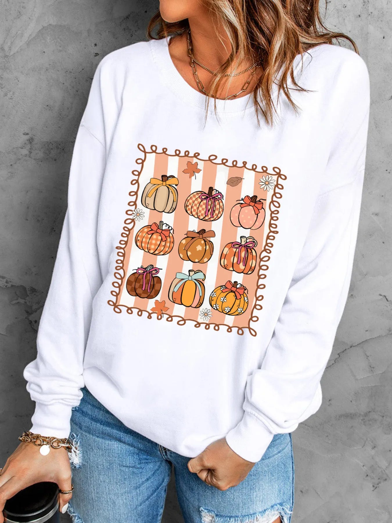 Slightly Stretchy Pumpkin Graphic Round Neck Sweatshirt for Fall in white, featuring a fun pumpkin design, paired with distressed denim shorts, perfect for autumn wear.