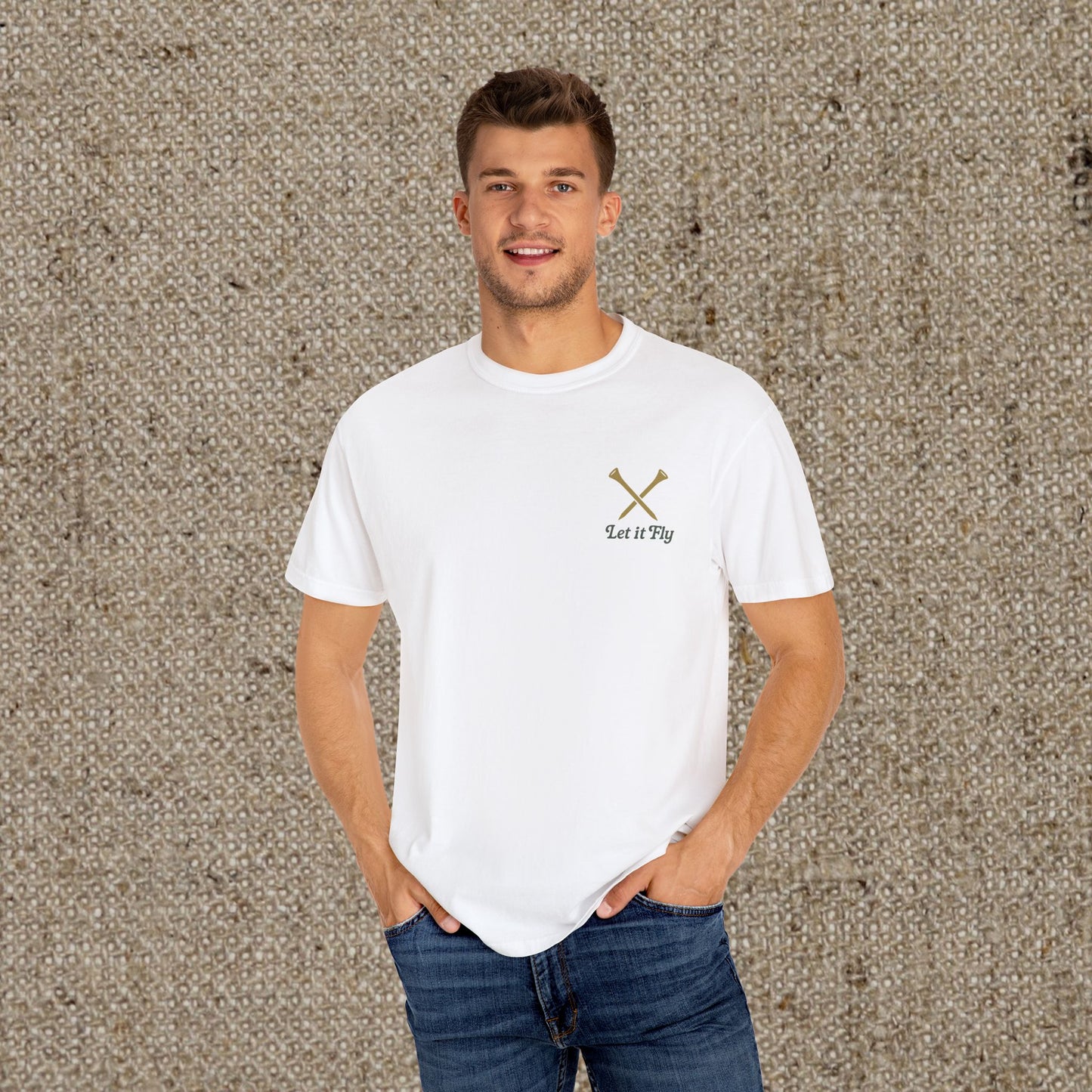 Model wearing a white Tee It High Let It Fly Graphic Tee, featuring 'Let It Fly' text and crossed golf clubs, exuding a stylish and laid-back vibe.