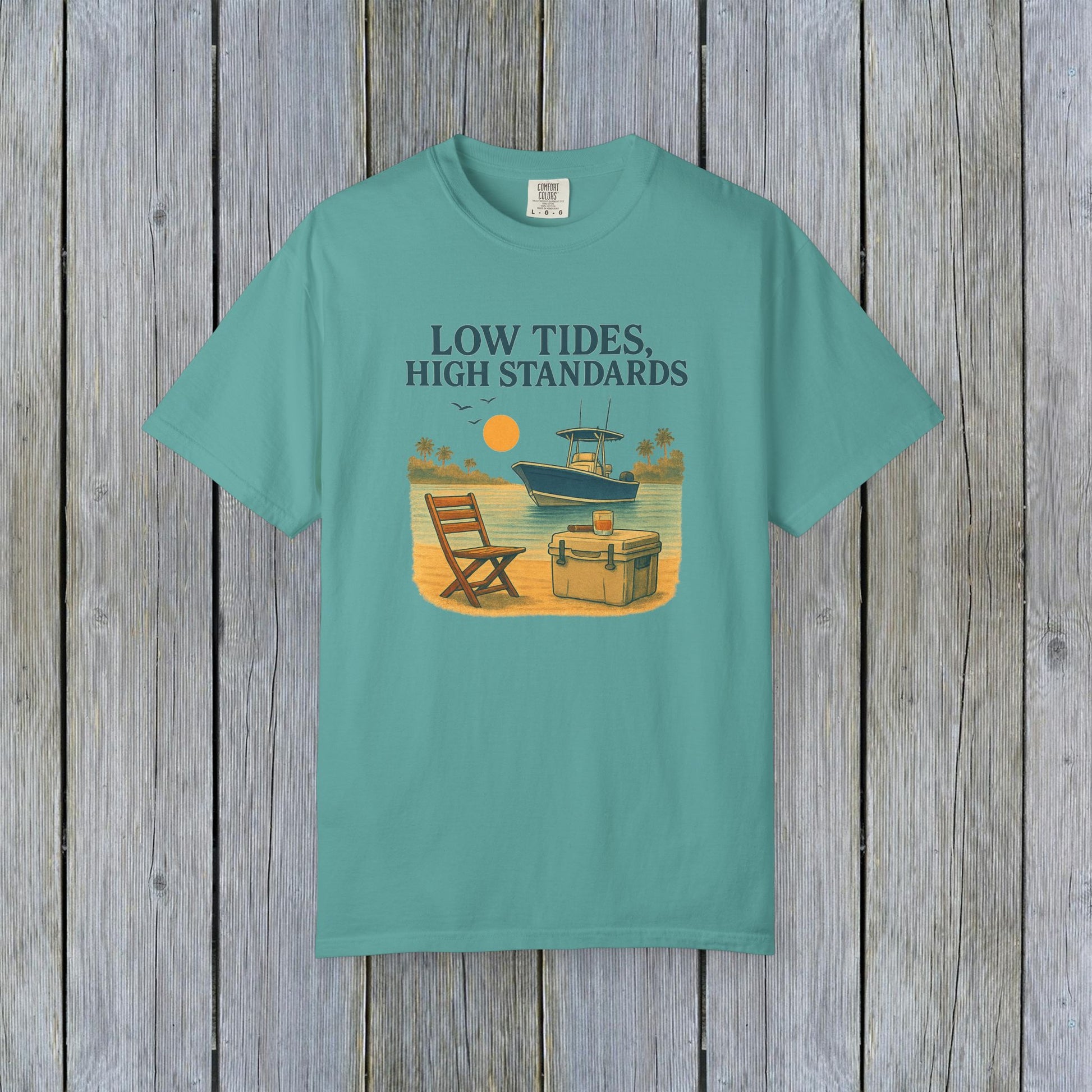 Garment-Dyed Low Tides High Standards T-Shirt in teal color, showcasing a relaxing beach vibe with a boat and sunset, perfect for summer outings.