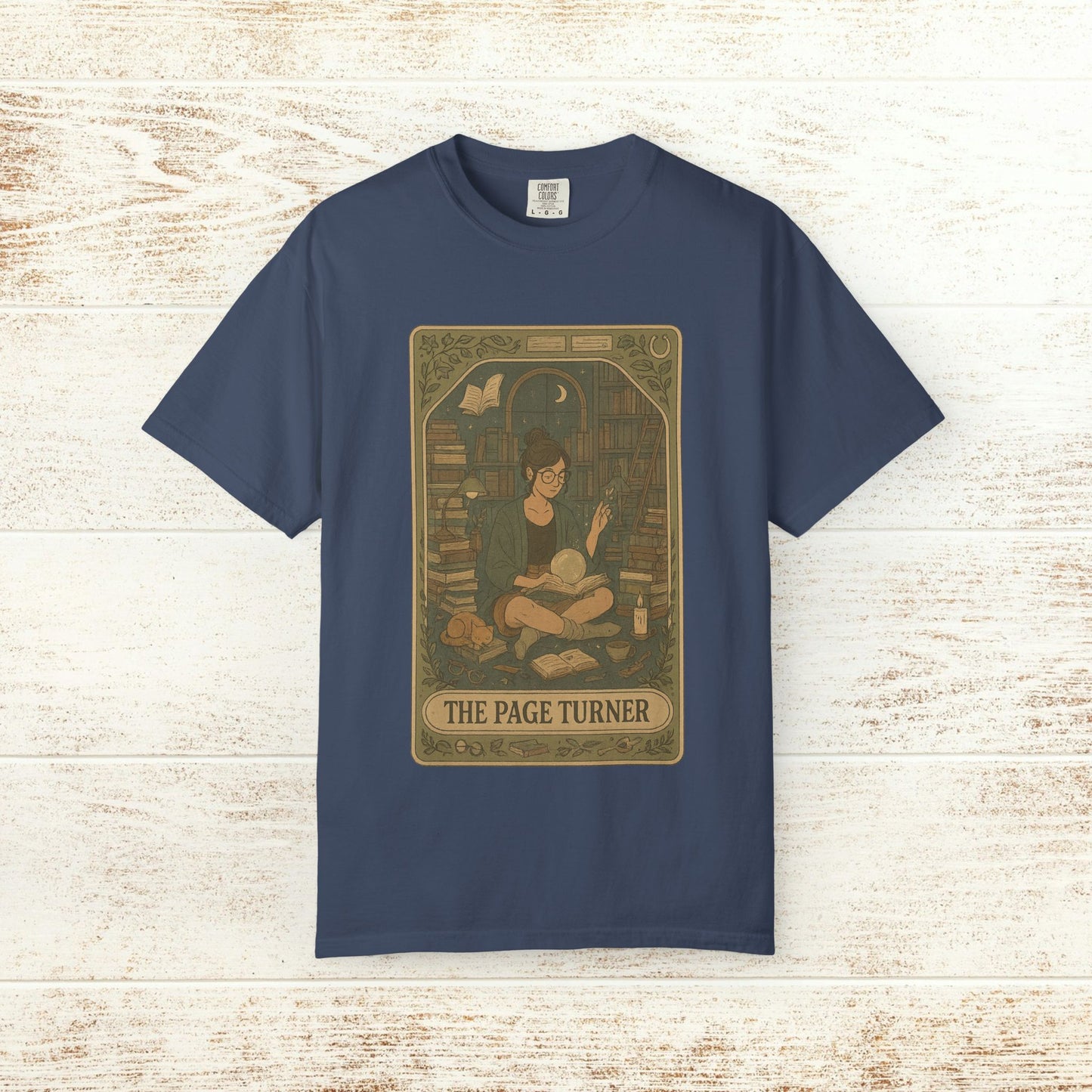 Page Turner Tarot Tee - A vibrant navy soft cotton t-shirt with an artistic depiction of a person enjoying a good book, available in sizes S to 4XL.