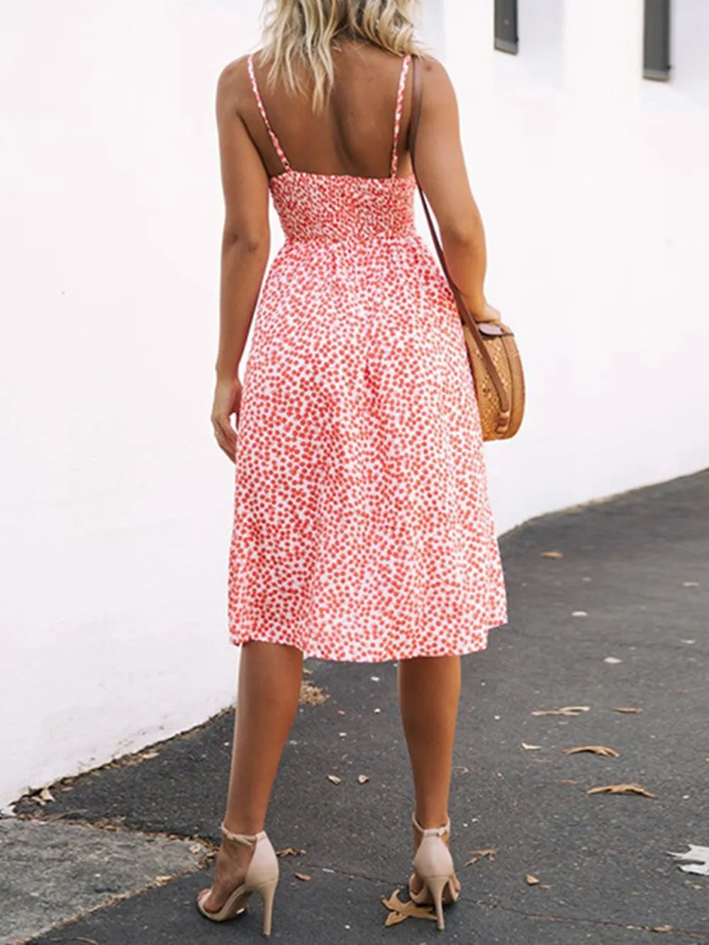 Back view of the red floral Cutout Smocked Sweetheart Neck Cami Dress with Decorative Button and Opaque Design, showcasing the smocked back and flowy design.