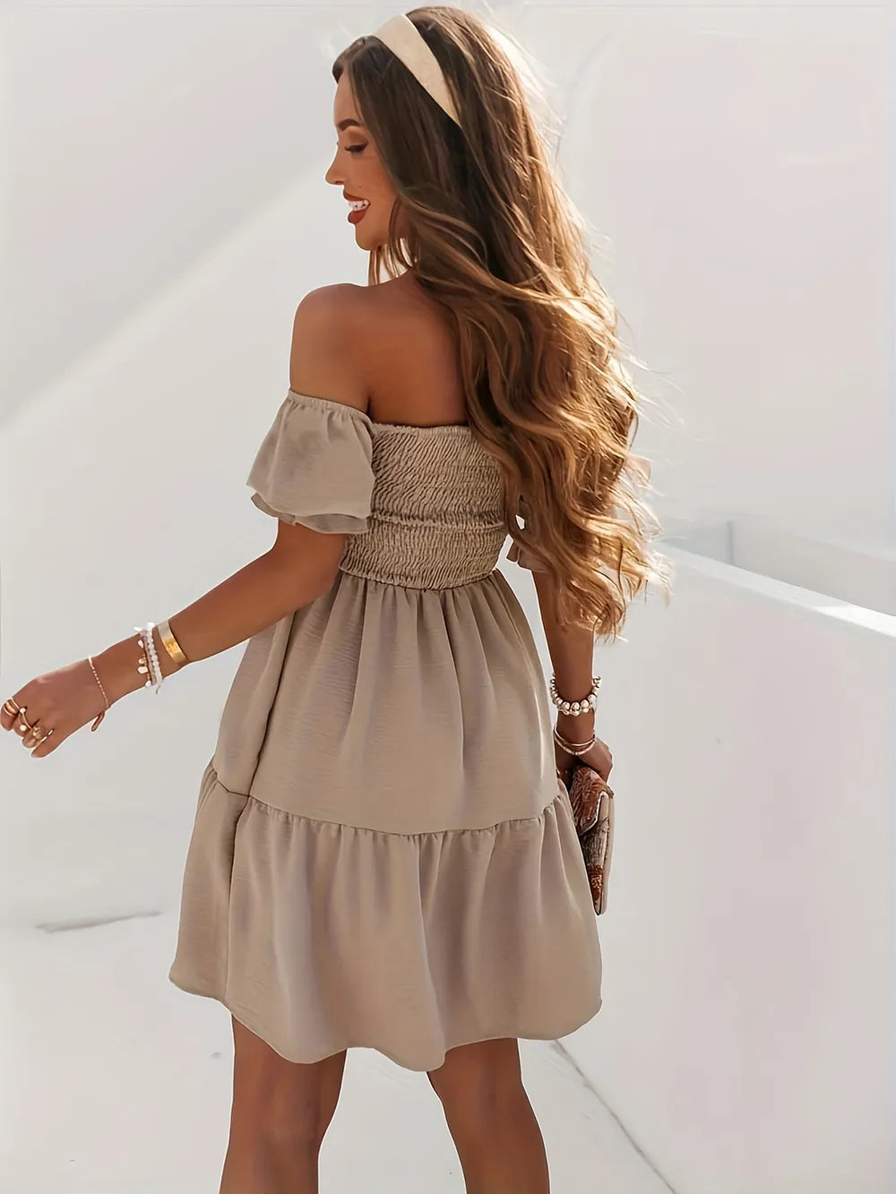 Back view of the Full Size Ruffled Off-Shoulder Dress with Short Sleeves - Stretchy, Chic & Ruched Design, highlighting the ruched bodice and flowy skirt in beige on a model.