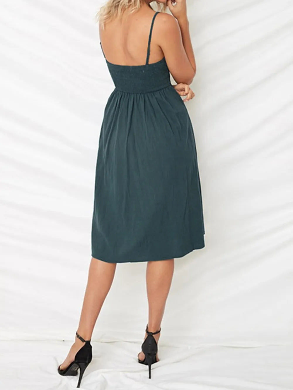 Back view of a Model in a dark green Cutout Smocked Sweetheart Neck Cami Dress with Decorative Button and Opaque Design, showing the smocked detail.