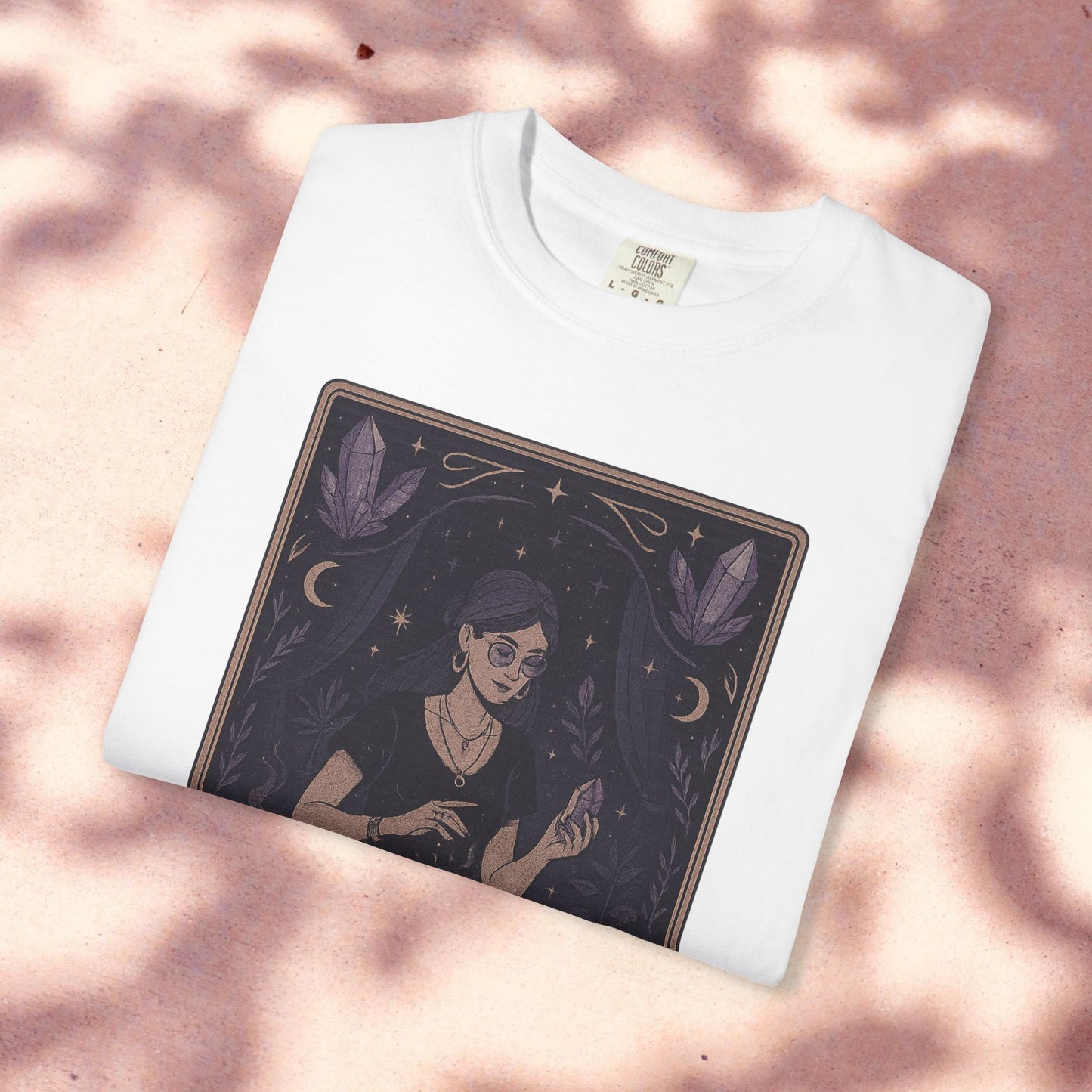 Intuitive Tarot Tee displayed on a light pink background, featuring a woman with glasses and crystals, crafted from premium 100% cotton.