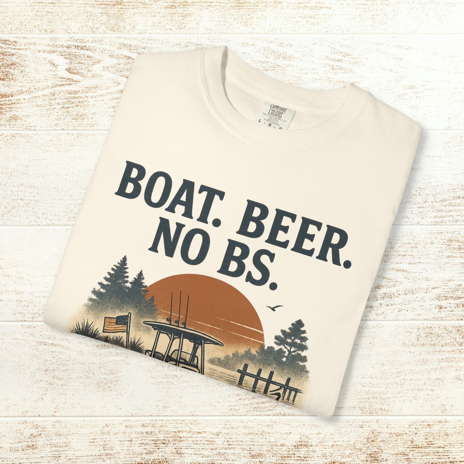 Boat Beer No BS Tee folded neatly on a wooden surface, featuring a classic design with a sunset backdrop.