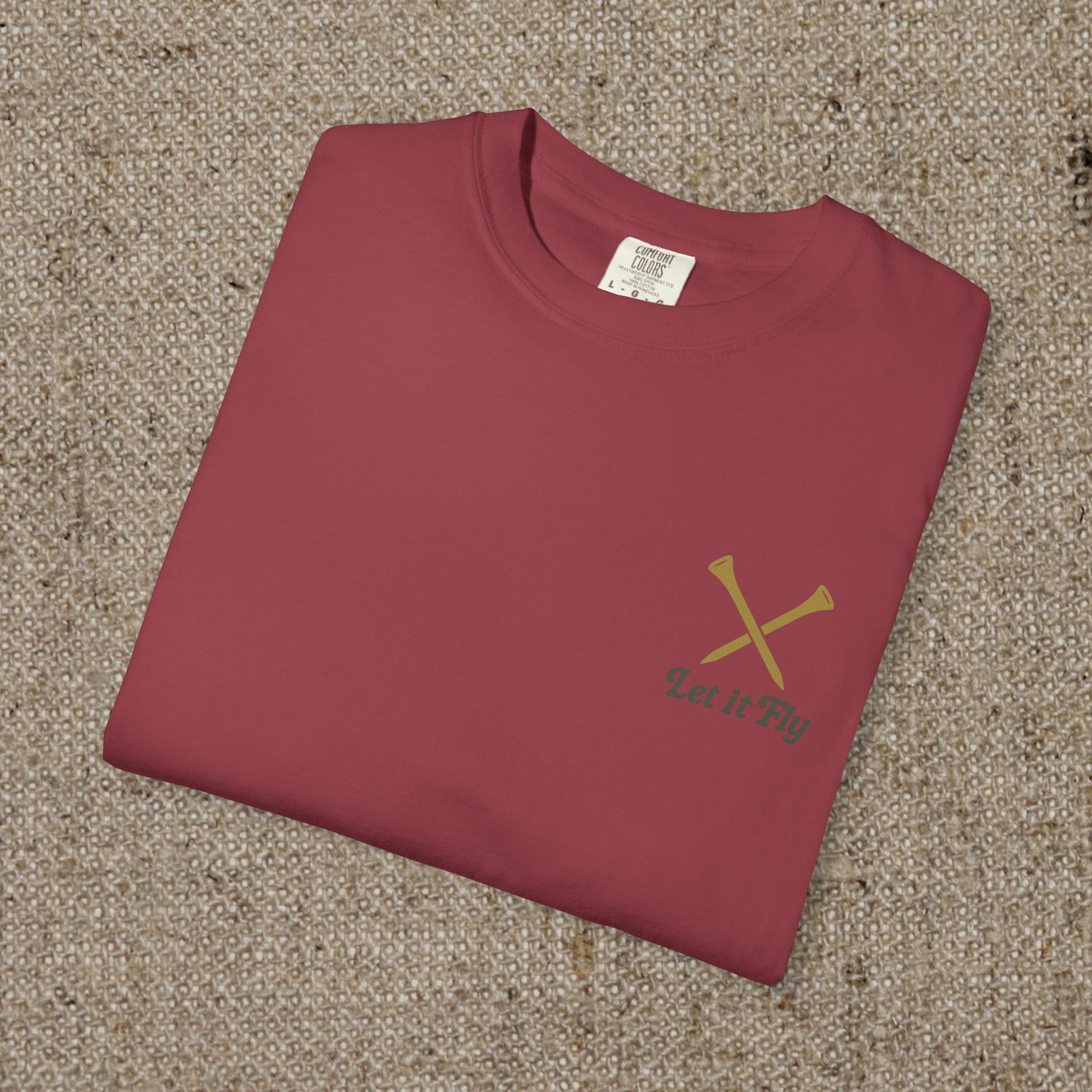 Tee It High Let It Fly Graphic Tee in maroon, neatly folded and displayed on a textured surface, highlighting its soft cotton fabric and durable design.
