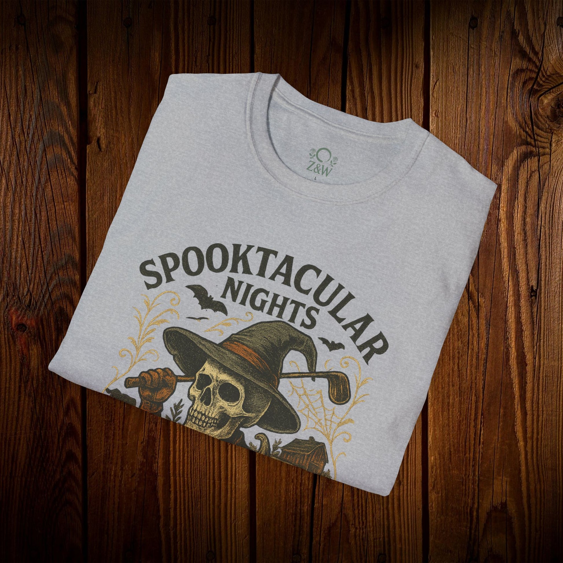 Spooktacular Nights Halloween T-Shirt for Unisex folded and featuring a stylish skull and pumpkin design, perfect for festive fall celebrations.