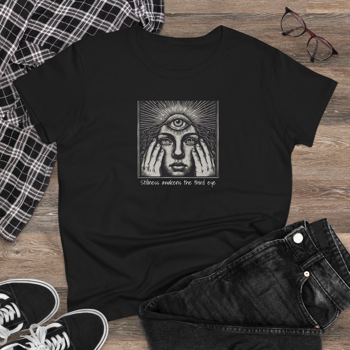 Stylish Third Eye Graphic Tee laid flat on a wooden surface, showcasing the striking graphic and comfortable black fabric.