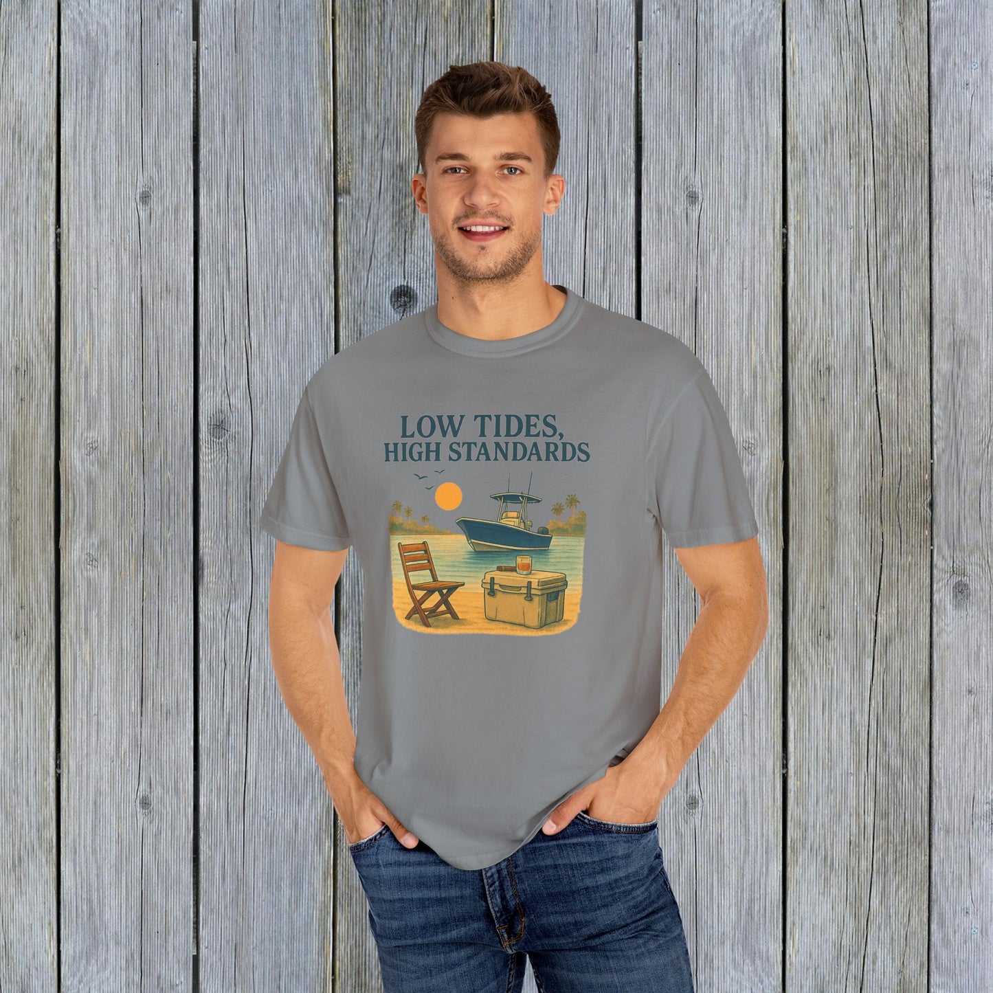 Man in a gray Garment-Dyed Low Tides High Standards T-Shirt, showing off the stylish beach graphic. A go-to choice for comfort and casual style.