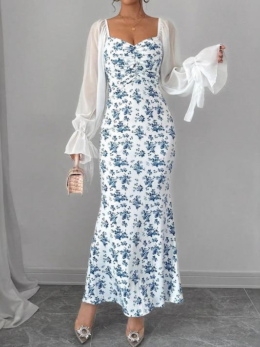 Floral Print Maxi Dress with Sweetheart Neckline and Ruffled Design showcased by a model, featuring a white base adorned with blue floral patterns.