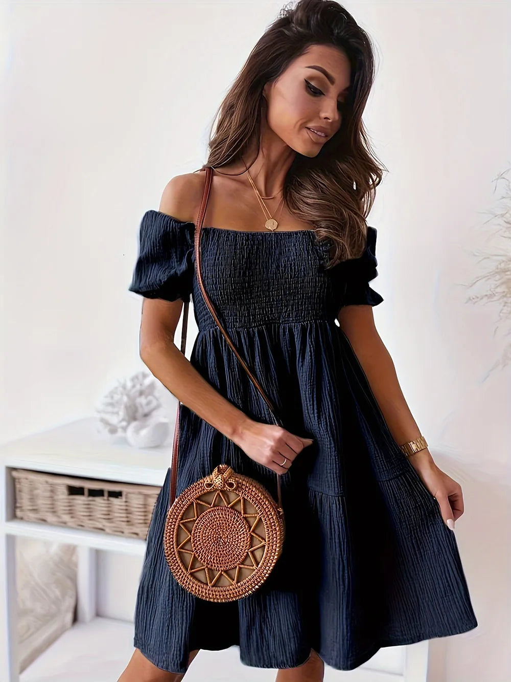 Full Size Ruffled Off-Shoulder Dress with Short Sleeves - Stretchy, Chic & Ruched Design in navy blue, featuring a model standing gracefully with a stylish bag.