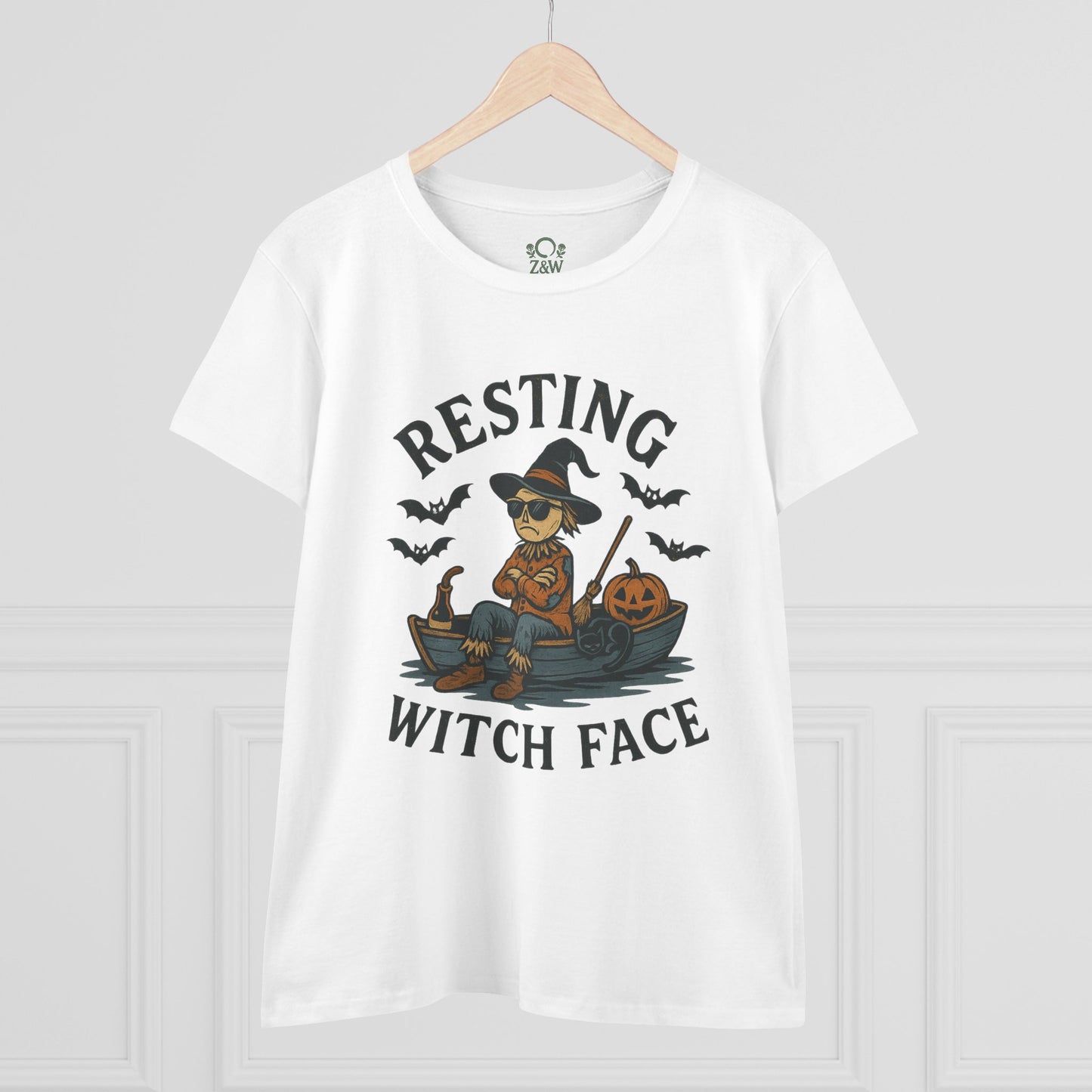 Front view of the 'Resting Witch Face Halloween T-Shirt for Women, Unisex Funny Cotton Tee for Parties and Gifts', showcasing a witch character sitting on a boat with Halloween pumpkins and bats.
