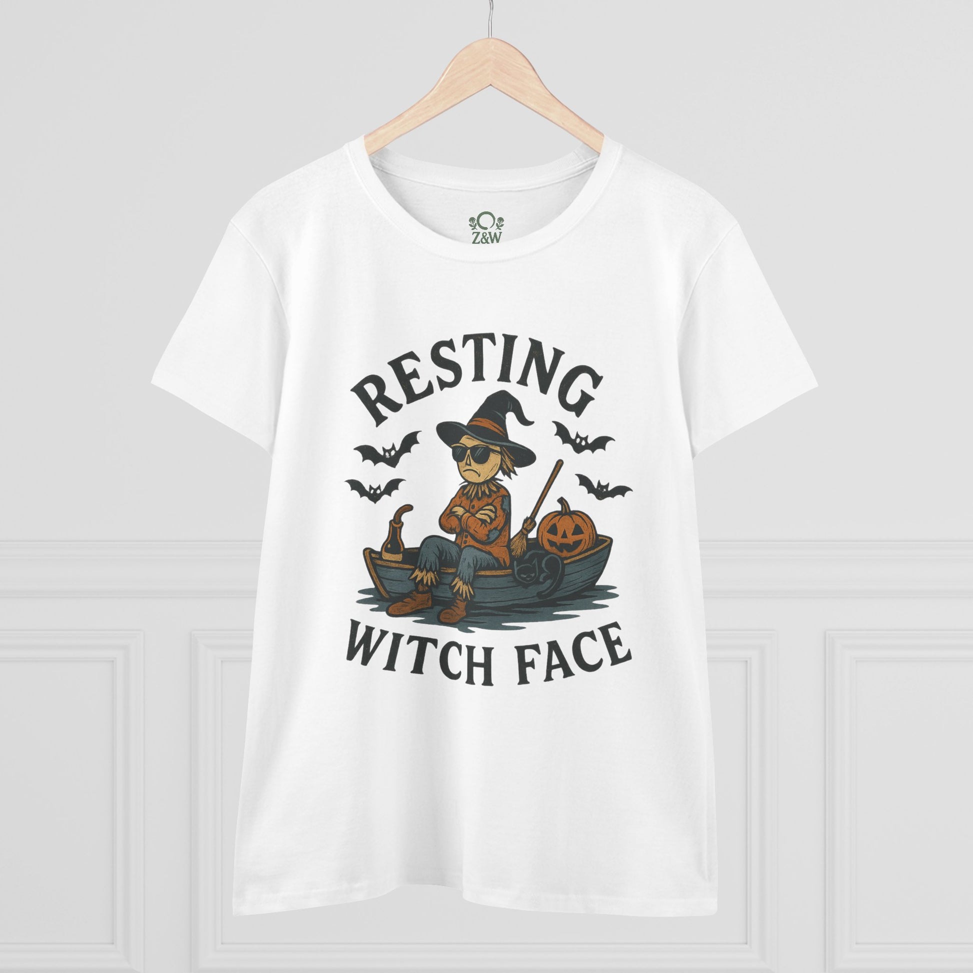 Front view of the 'Resting Witch Face Halloween T-Shirt for Women, Unisex Funny Cotton Tee for Parties and Gifts', showcasing a witch character sitting on a boat with Halloween pumpkins and bats.