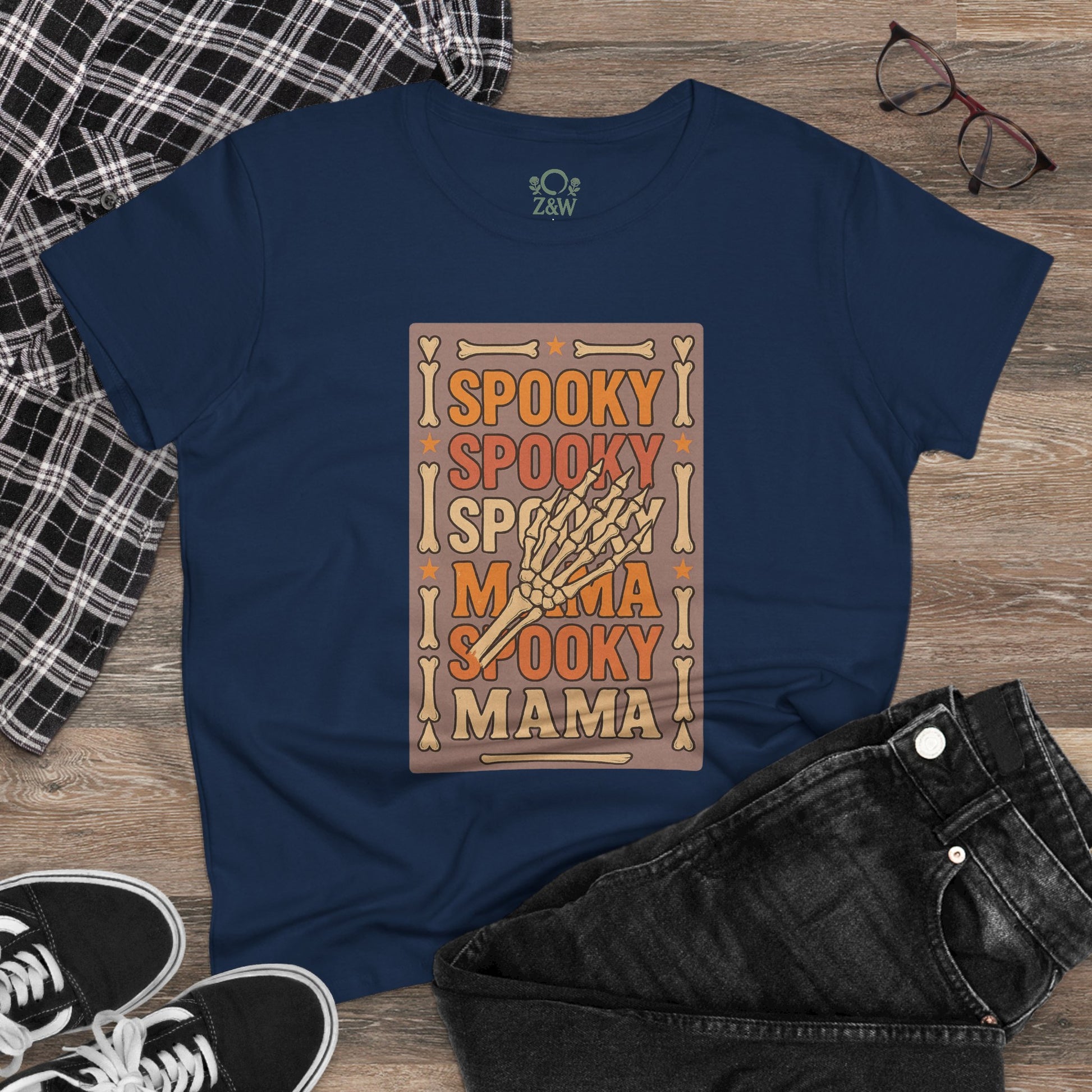 Spooky Mama Tee in navy blue laid flat with trendy jeans and sneakers, emphasizing its playful spooky design suitable for stylish and casual occasions.