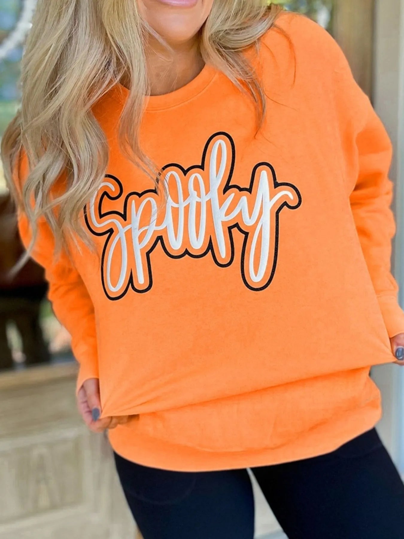 Chic Spooky Round Neck Long Sleeve Sweatshirt showcasing 'Spooky' print, perfect for a casual autumn outfit, paired with stylish black leggings.