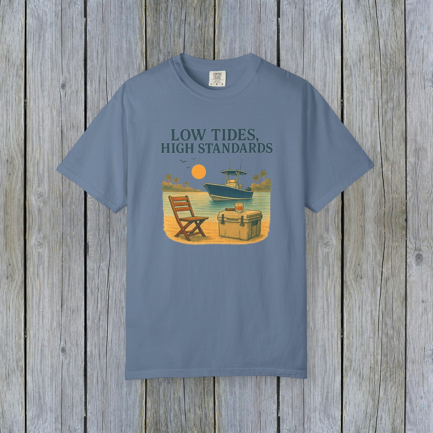 Garment-Dyed Low Tides High Standards T-Shirt in blue, showcasing a laid-back beach scene with a boat and chair, ideal for casual outings.