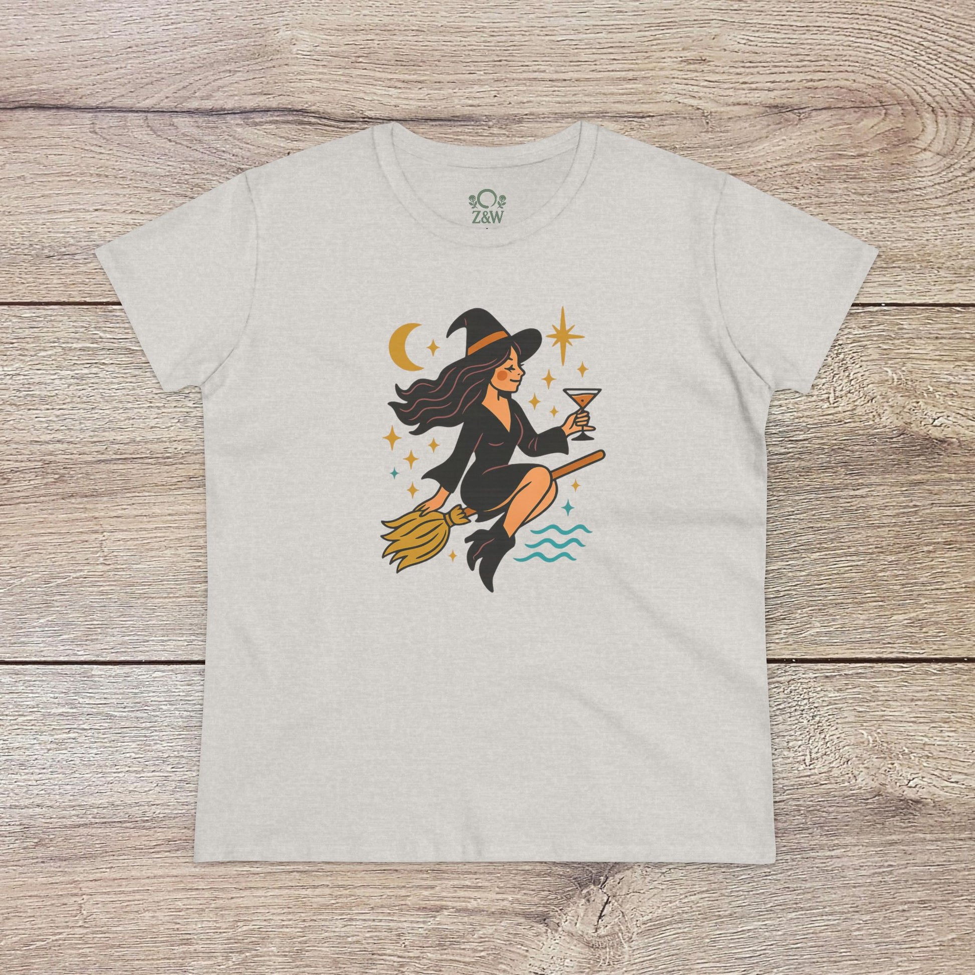 Witchy Night Out Tee in light gray showcasing a whimsical witch on a broom, designed with celestial elements, crafted from soft, sustainable ring-spun cotton for comfort.