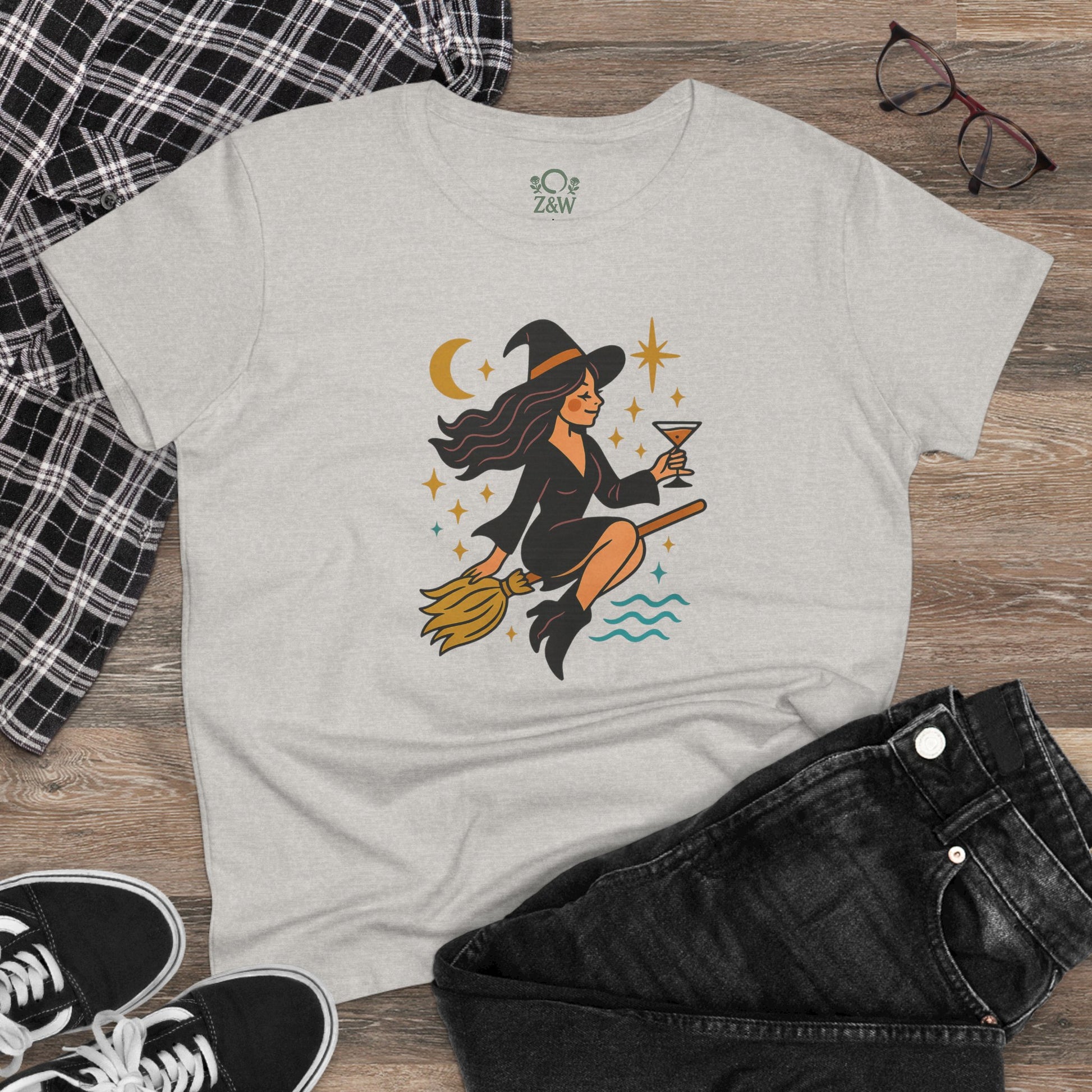 Casual view of the Witchy Night Out Tee showcasing a chic witch on a broomstick, complemented with jeans and a plaid shirt.