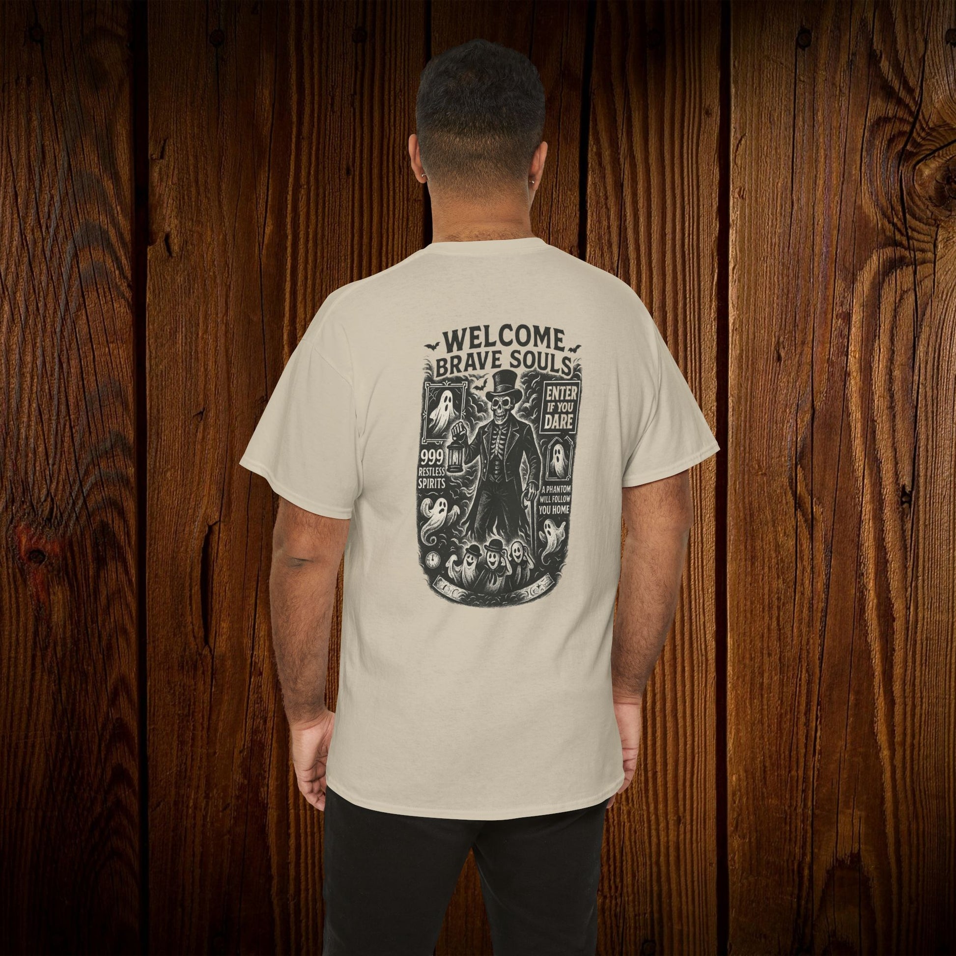 Back view of a Spooky Halloween Graphic Tee featuring a spooky design, ideal for Halloween celebrations, modeled by a man showcasing the shirt against a wooden background.