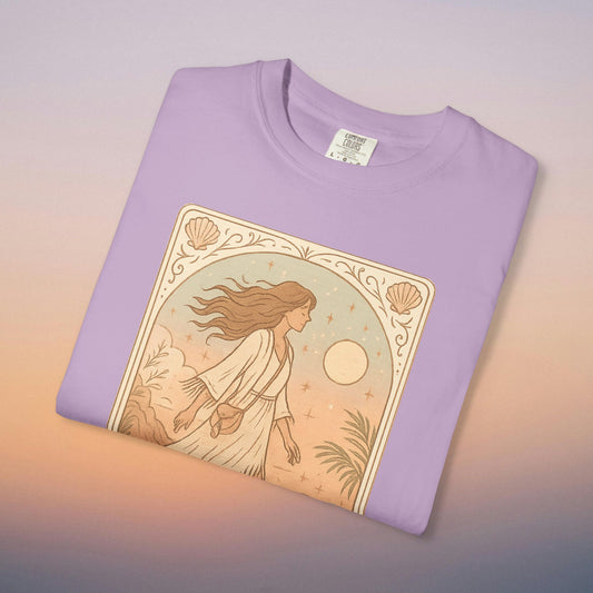 Wanderer Tarot Graphic Tee in light lavender color, showcasing a unique artistic design of a woman in a flowy dress, capturing the essence of wanderlust. Ethically made with 100% cotton, available in sizes S to 4XL for ultimate comfort and style.